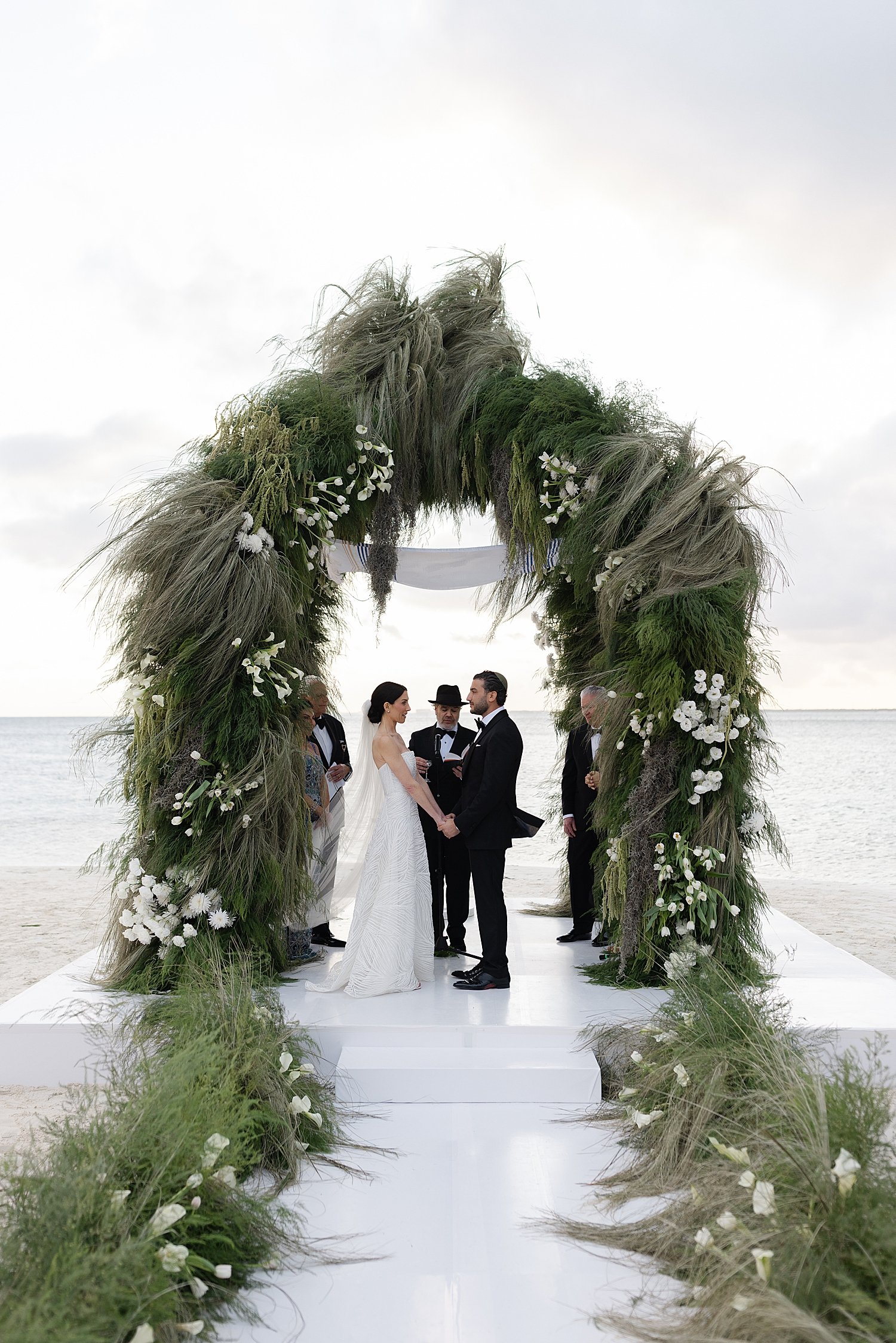  bride and groom under chuppah  