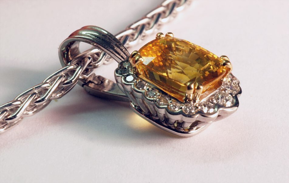 Yellow Sapphire Surround Diamond Pendant

With the warm glow of autumn in full swing we couldn't resist getting our own warm glow going.. 4.25ct. cushion cut yellow sapphire set in 18KT white gold and accompanied by graduated round brilliant shaped d