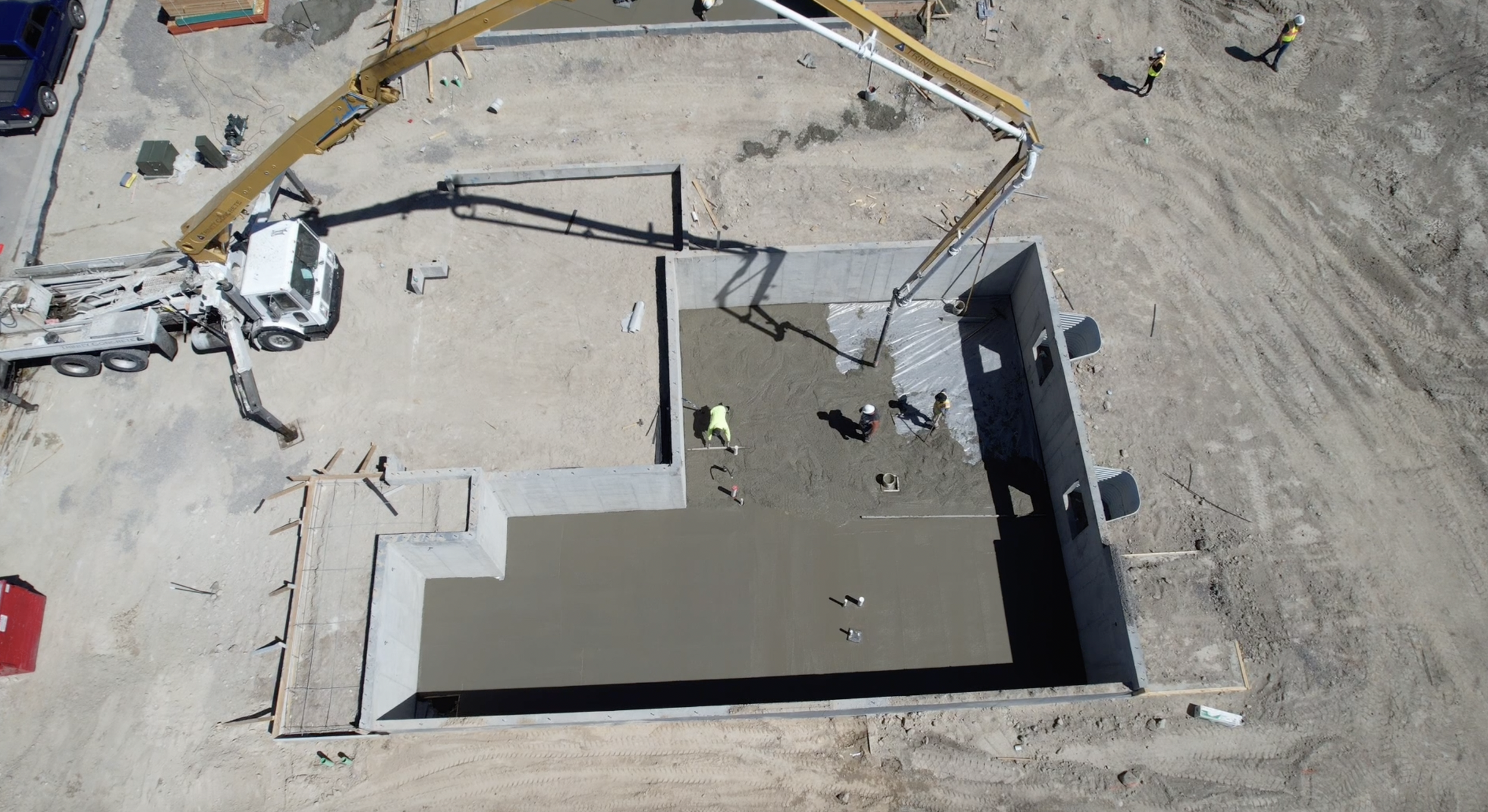 Drone shot of Trinity's boom pump pumping concrete into a basement construction.