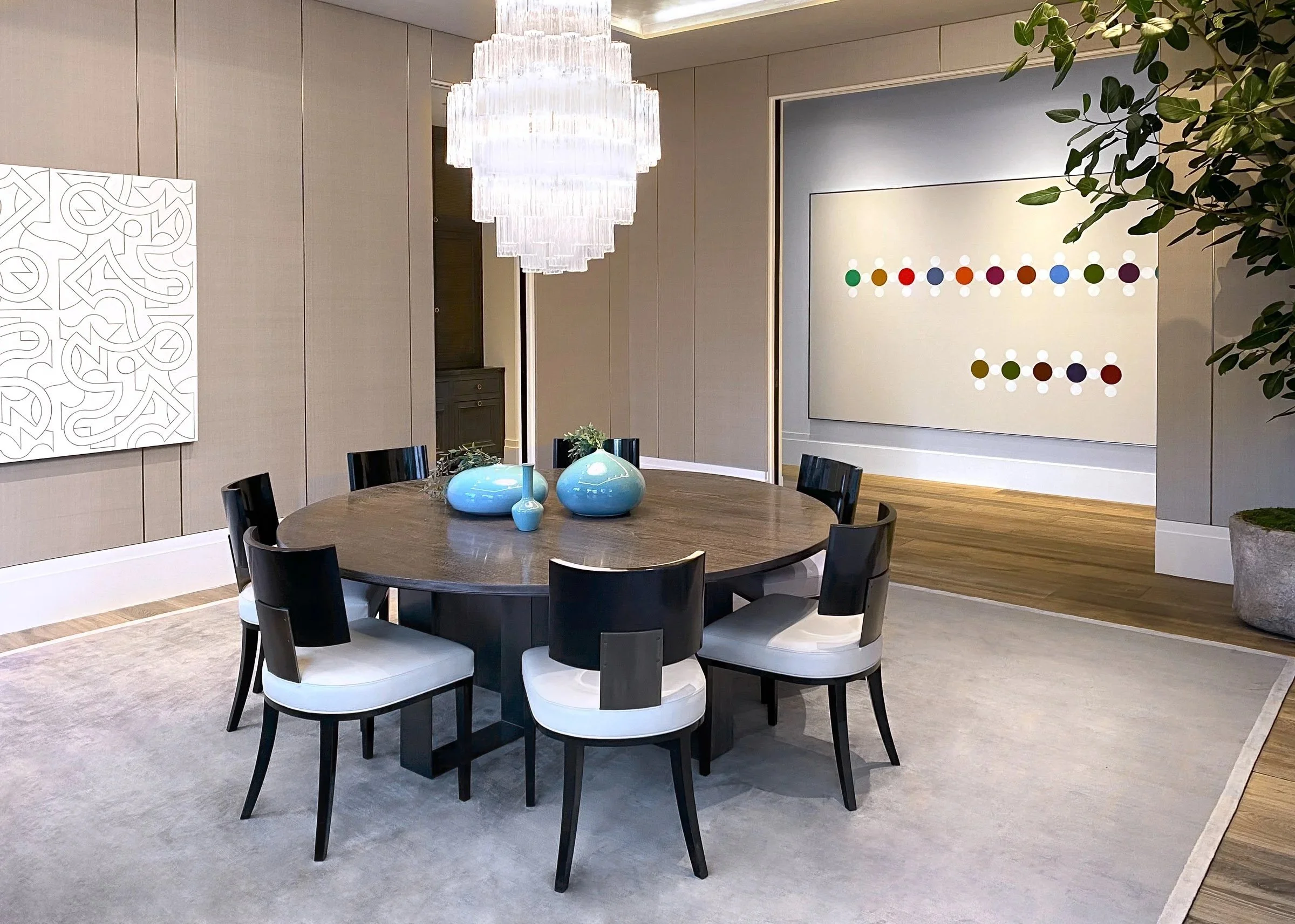 Dining table with modern chandelier and artwork on the wall