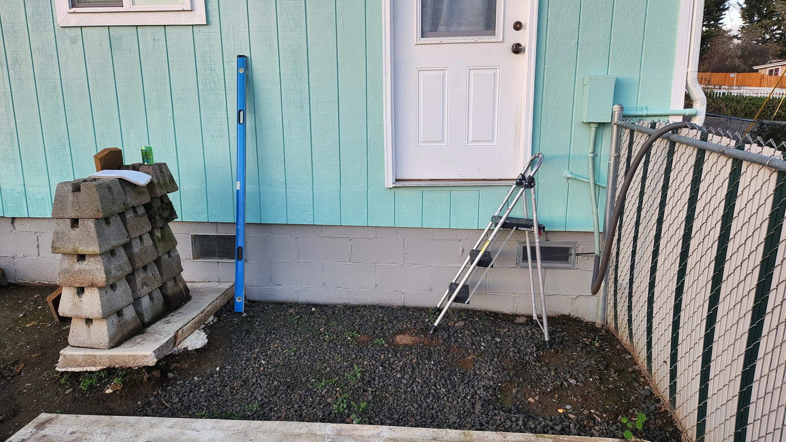 Exterior of a house with light blue siding, a white door without stairs or deck.