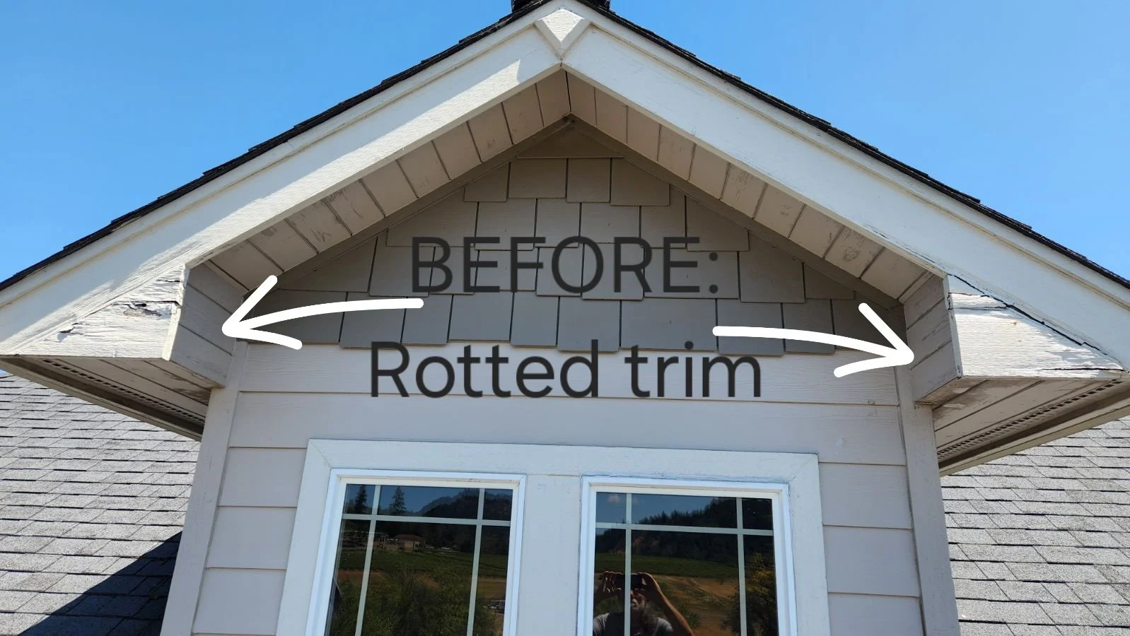 The peak of a house's gable with visible damaged or rotted trim on the edges, described as before