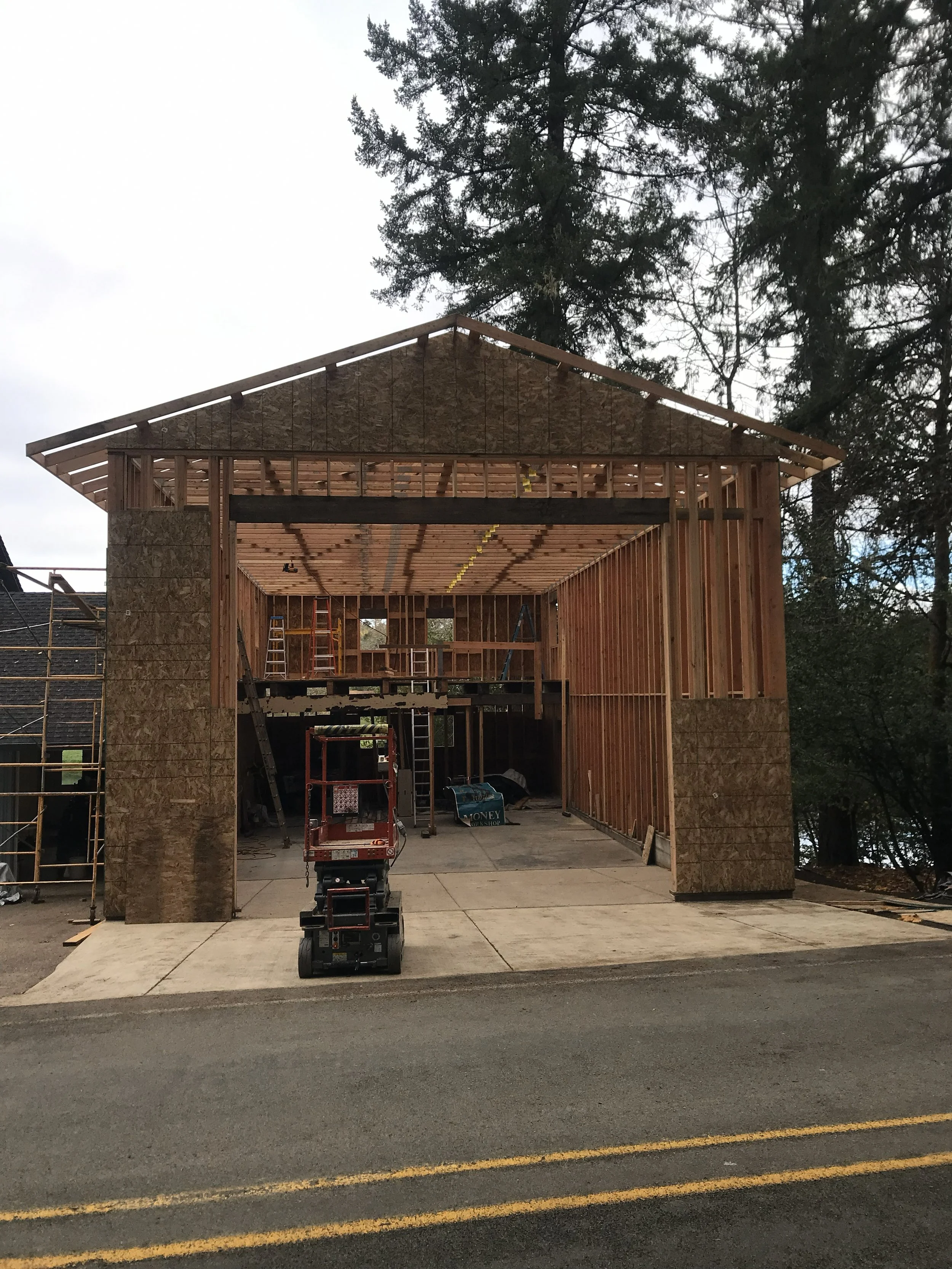 Construction site of a two-story wooden house showing the frame and roof structure displaying a work in progress of residential general contractor near Roseburg Oregon.