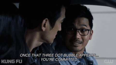 two men in a car one in glasses.