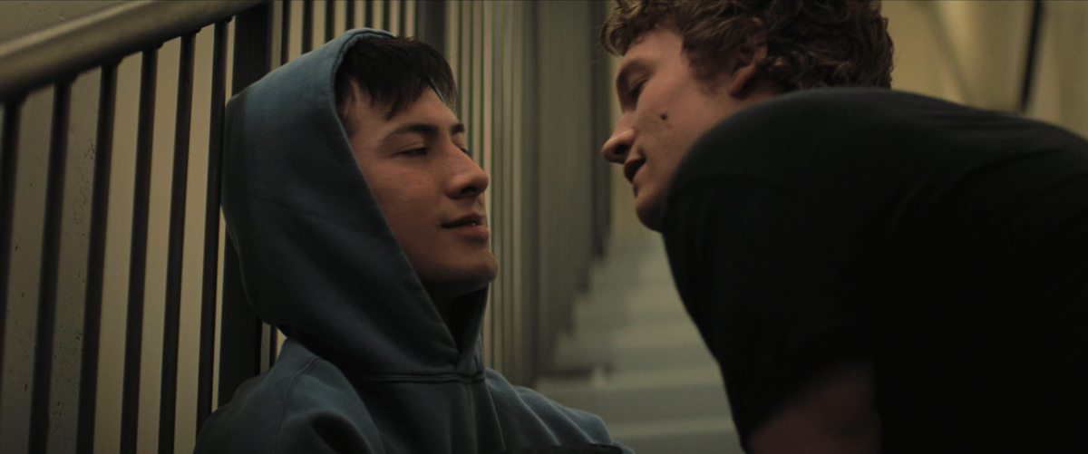 Still from Heated Rivalry episode 2 in the stairwell. Ilya leans in to kiss Shane.