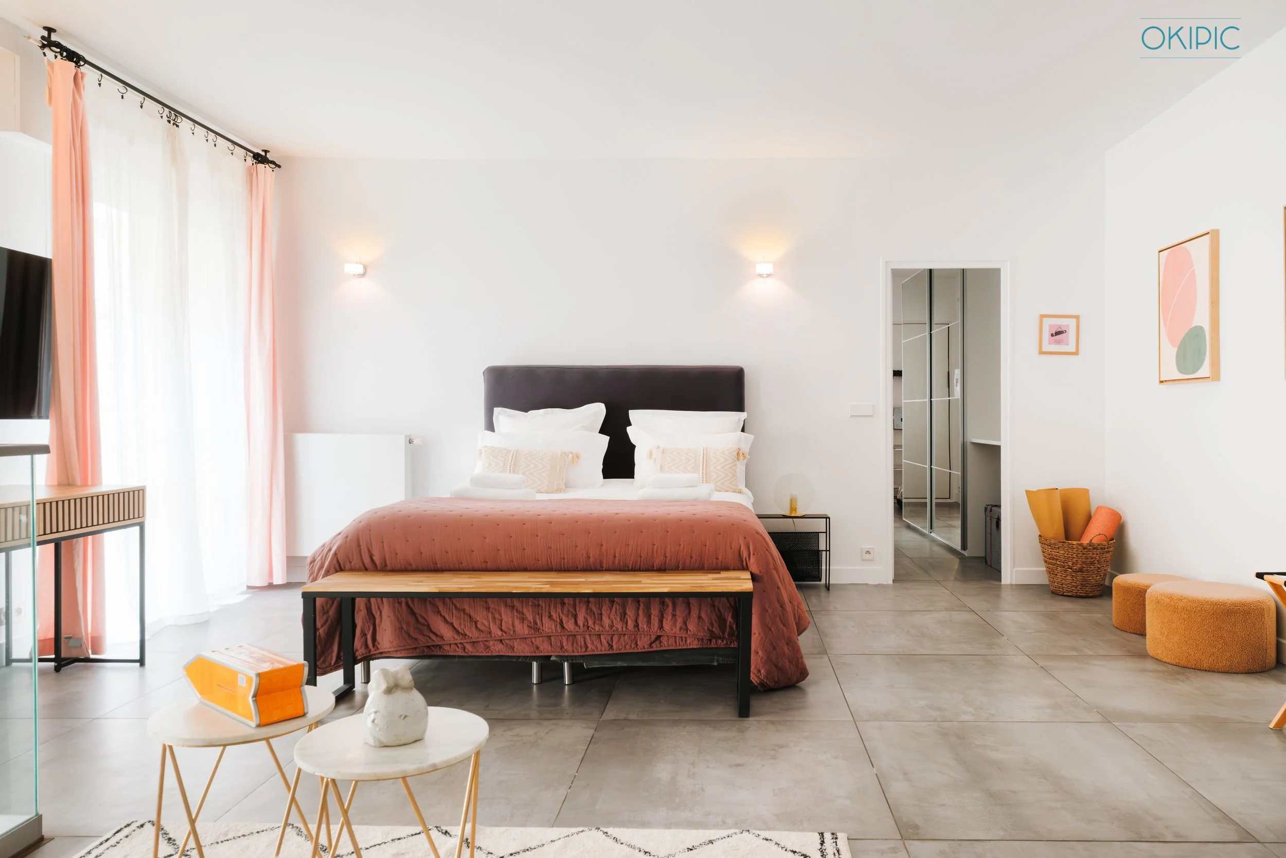 Bright suite (1) with large bed, chic decor, lounge seating, workspace & open wardrobe.