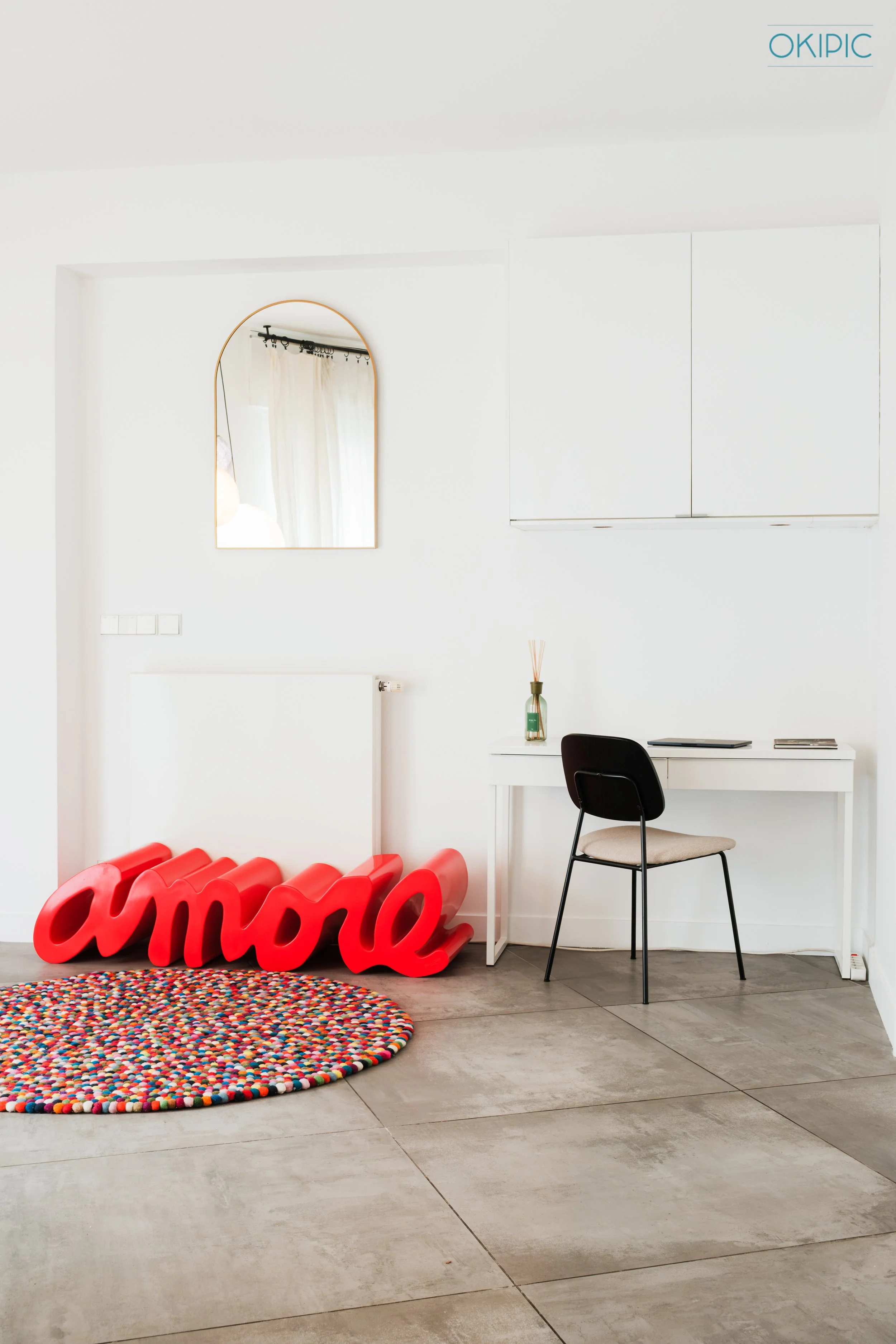 Sunny minimalist workspace with arch mirror and bold “amore” accent.