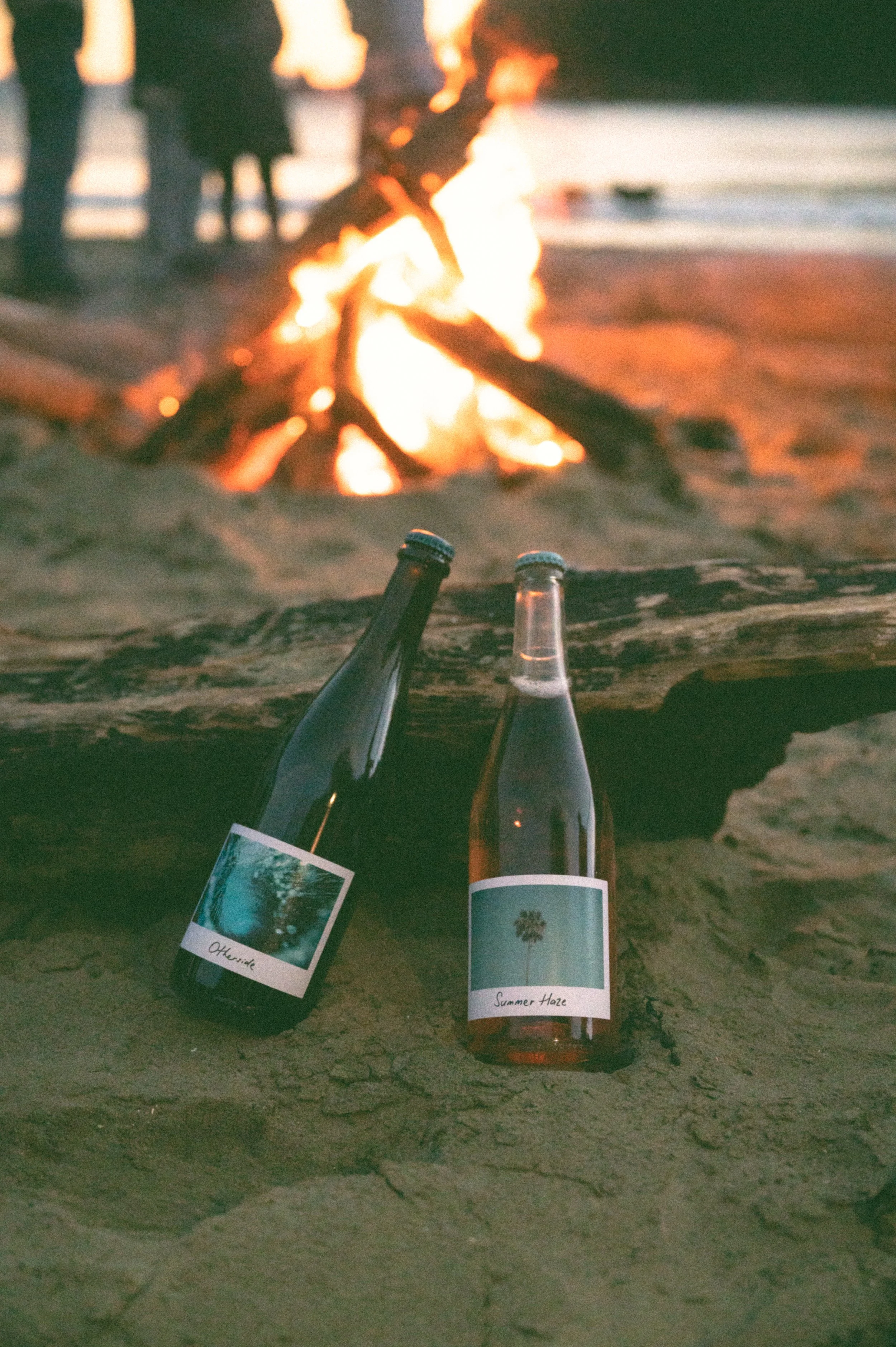 Ripple Effect Wines The Otherside and Summer Haze bottles in front of a beach bonfire