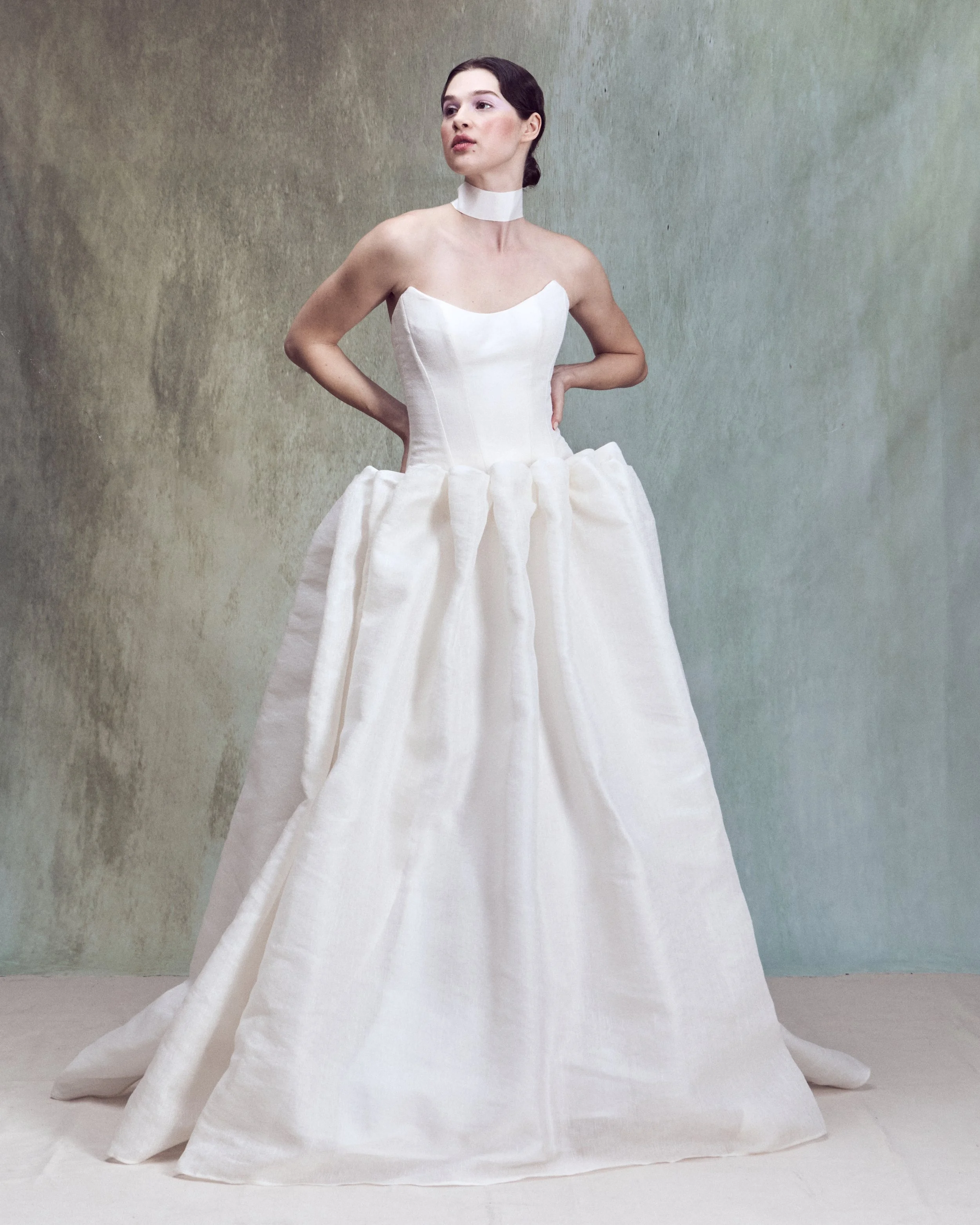 Strapless Silk Linen ball gown with a pointed neckline and a a drop-waist skirt, individually hand-draped into sculptural folds to create exaggerated volume