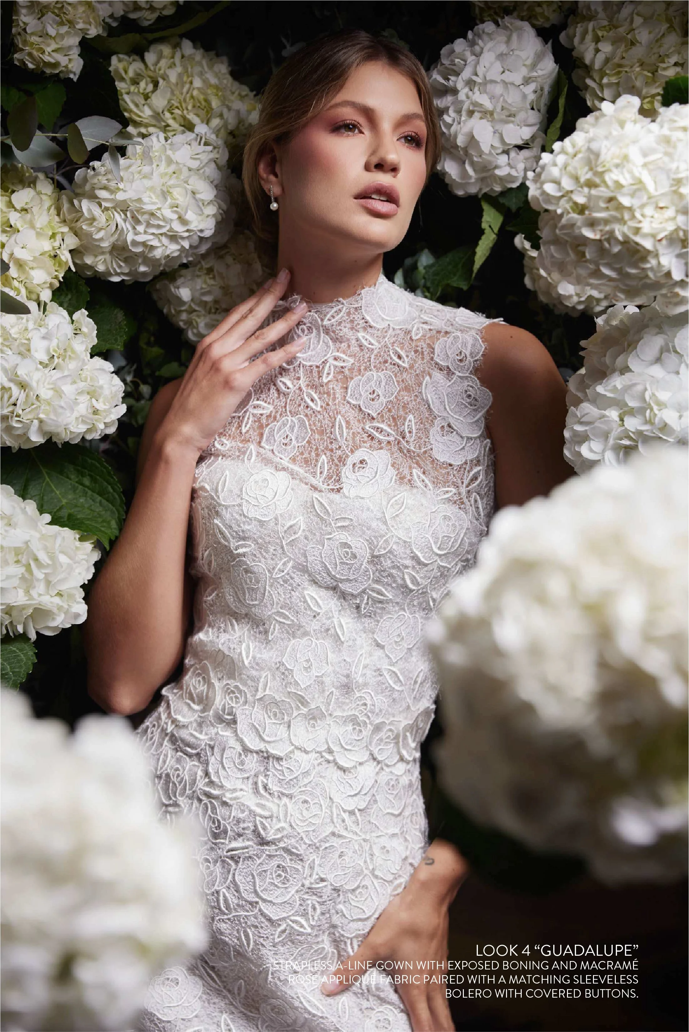 STRAPLESS A-LINE GOWN WITH EXPOSED BONING AND MACRAMÉ ROSE APPLIQUÉ FABRIC PAIRED WITH A MATCHING SLEEVELESS BOLERO WITH COVERED BUTTONS