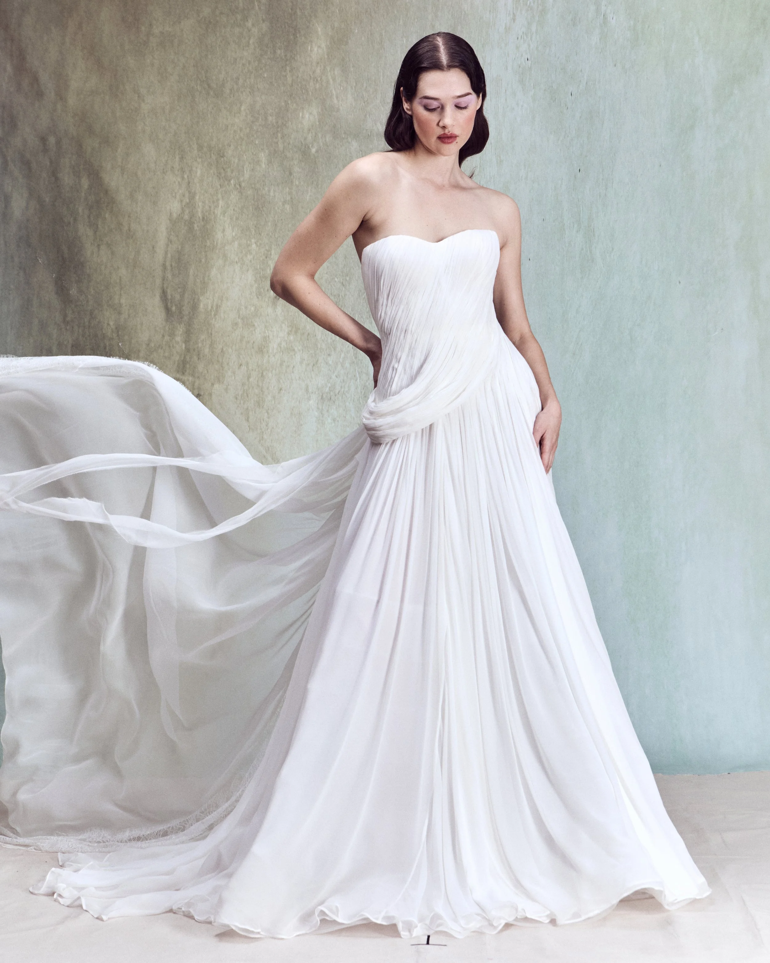 Hand-Draped Silk Chiffon gown with a structured bustier, continuous wraparound draping, and a soft ruffle at the back, with matching chiffon and lace train.