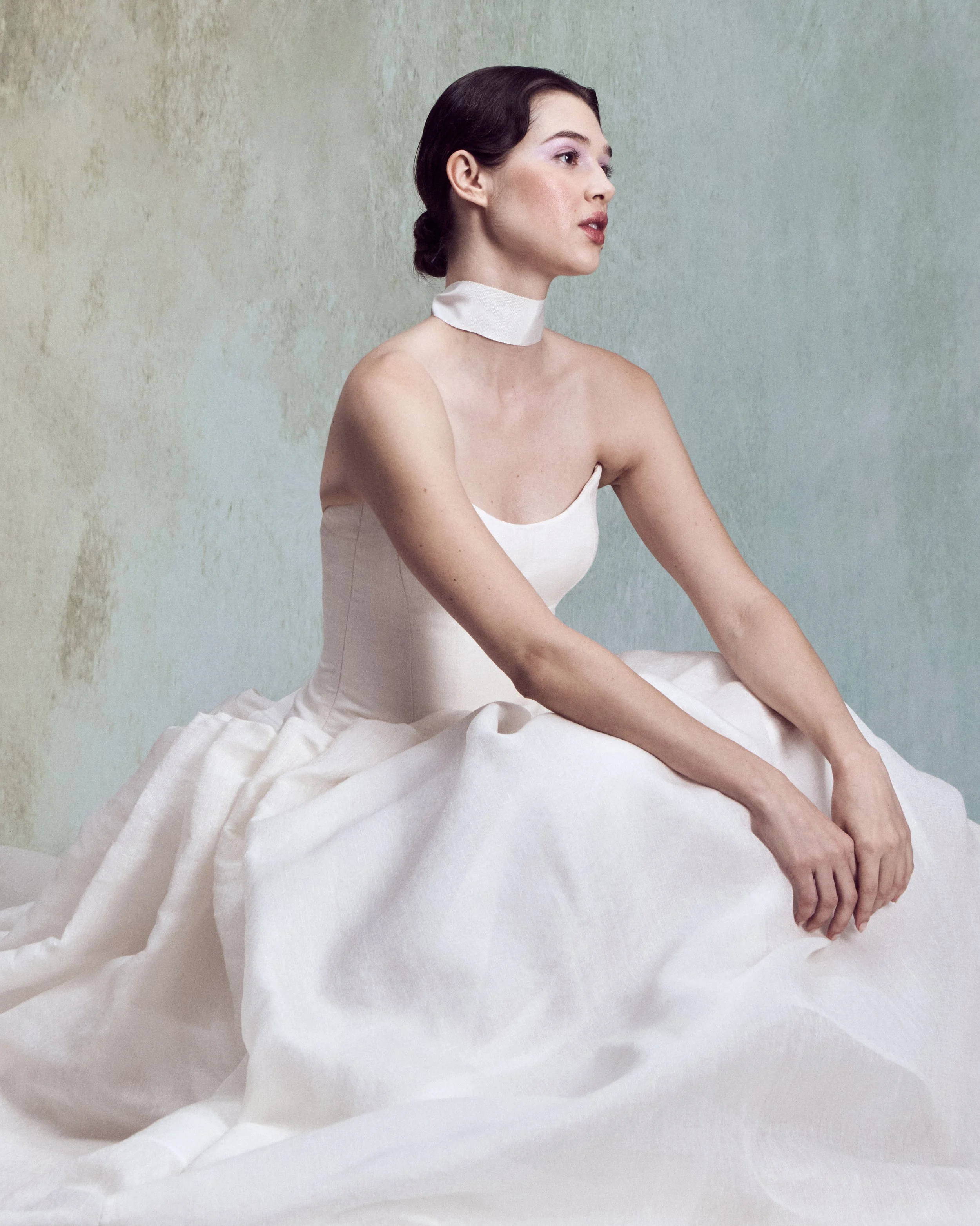 Strapless Silk Linen ball gown with a pointed neckline and a a drop-waist skirt, individually hand-draped into sculptural folds to create exaggerated volume