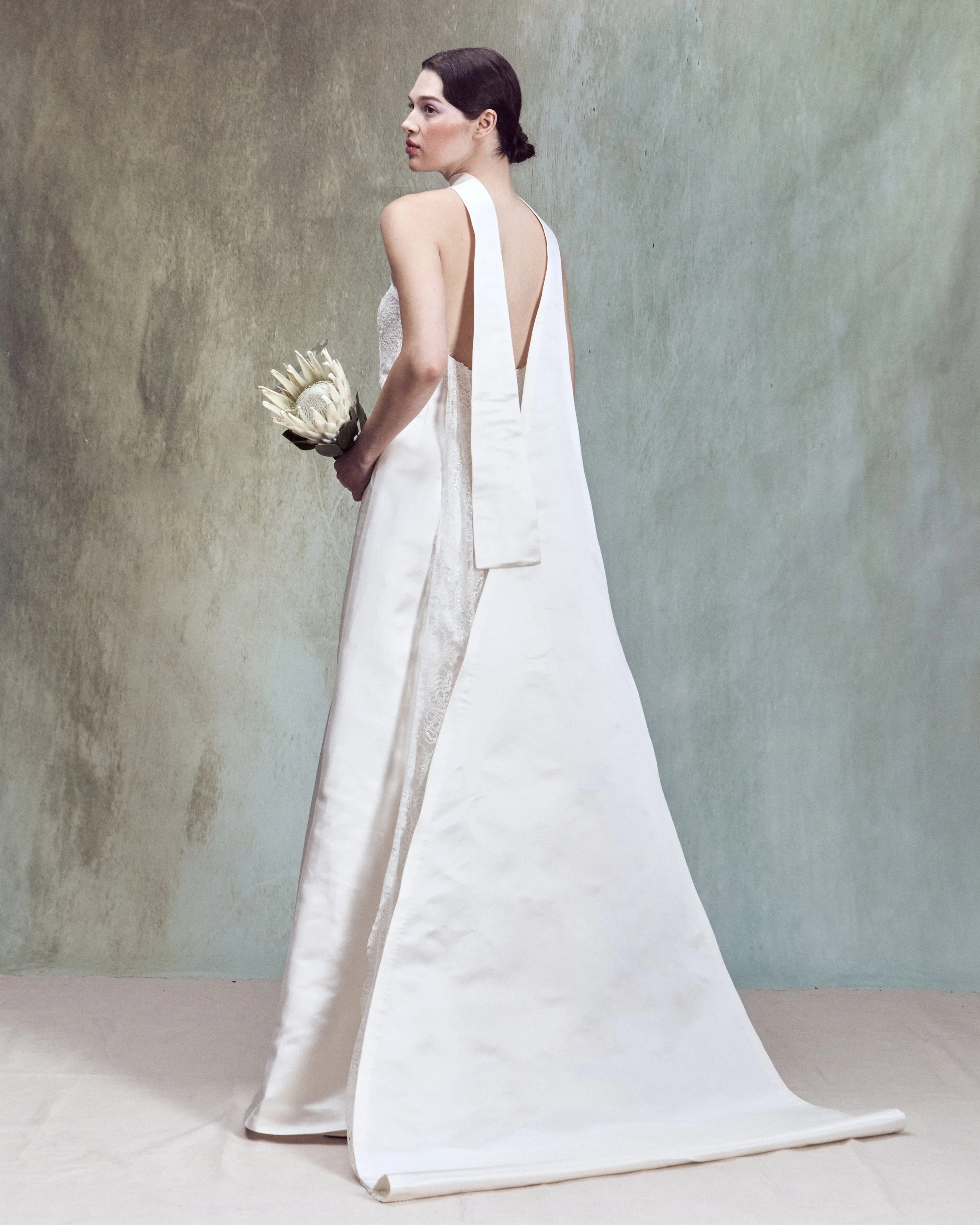 Strapless corded lace applique column gown with a low back, an integrated matching bustier, and removable folding train with chantilly lace detail inside.