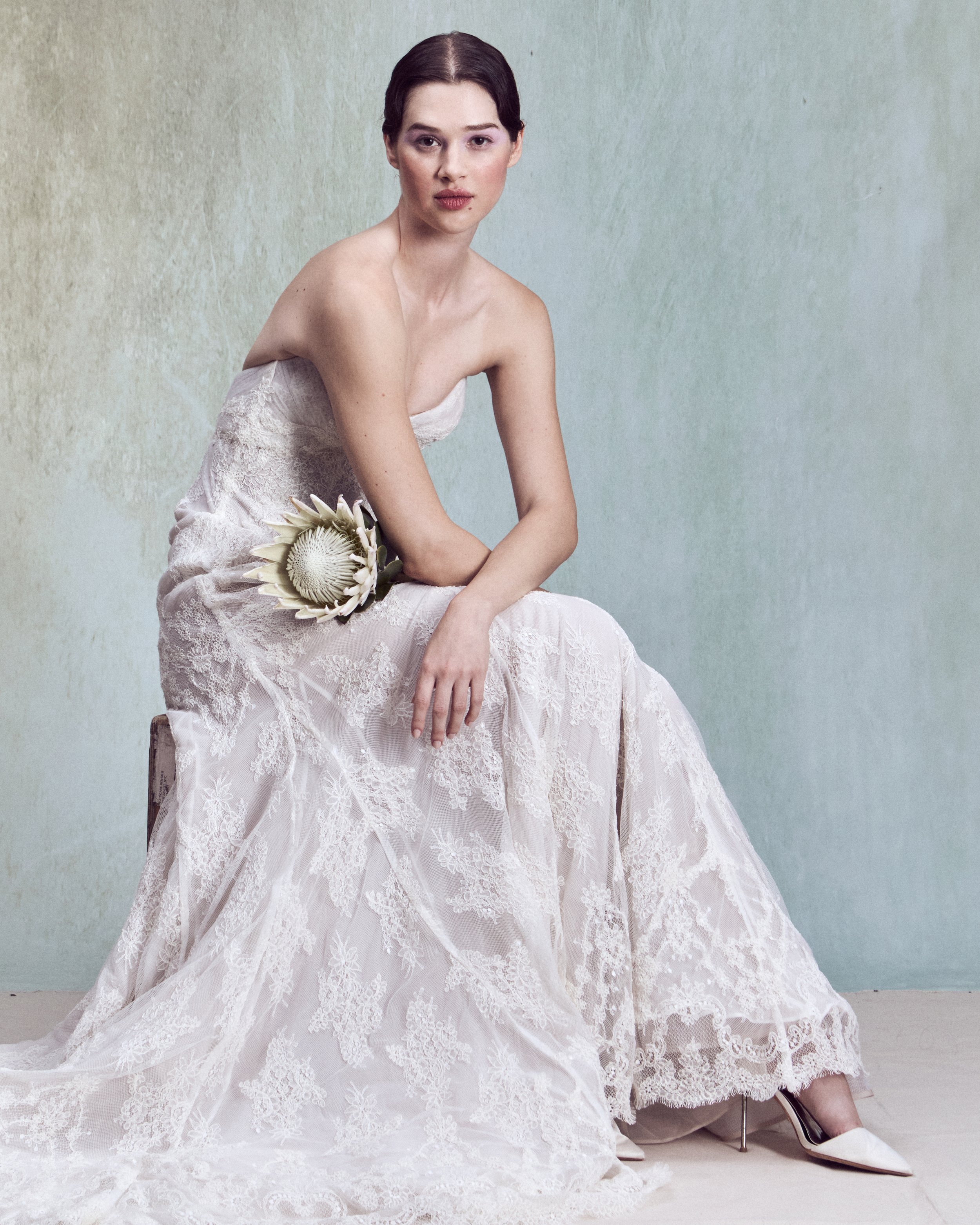 Strapless corded lace applique fit-and-flare gown with a V-shaped neckline and a internal corset matched with a scalloped corded lace capelet draped over the shoulders with an open back