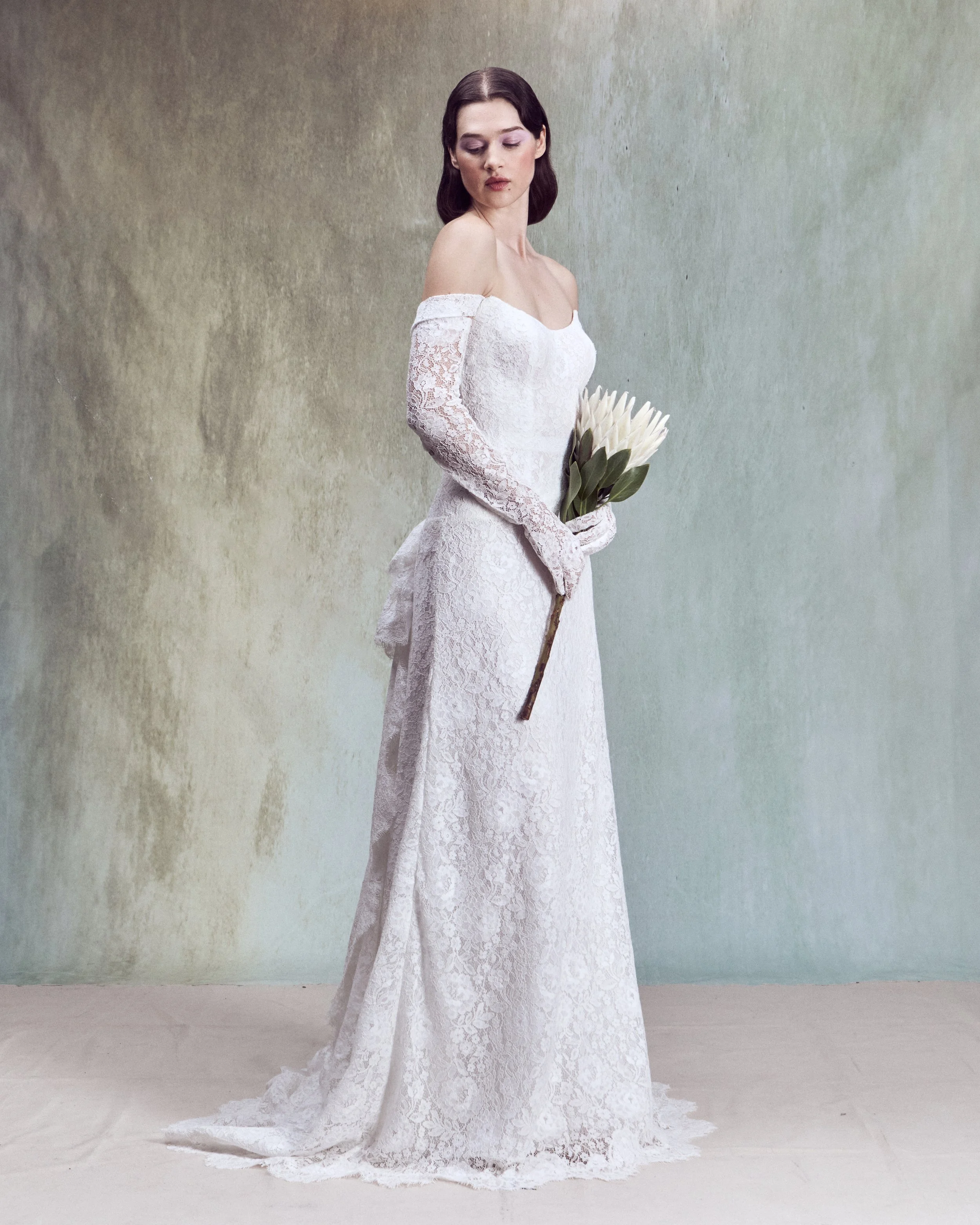Corded lace A-line with strapless drop-waist bustier and removable straps paired with matching gloves. 