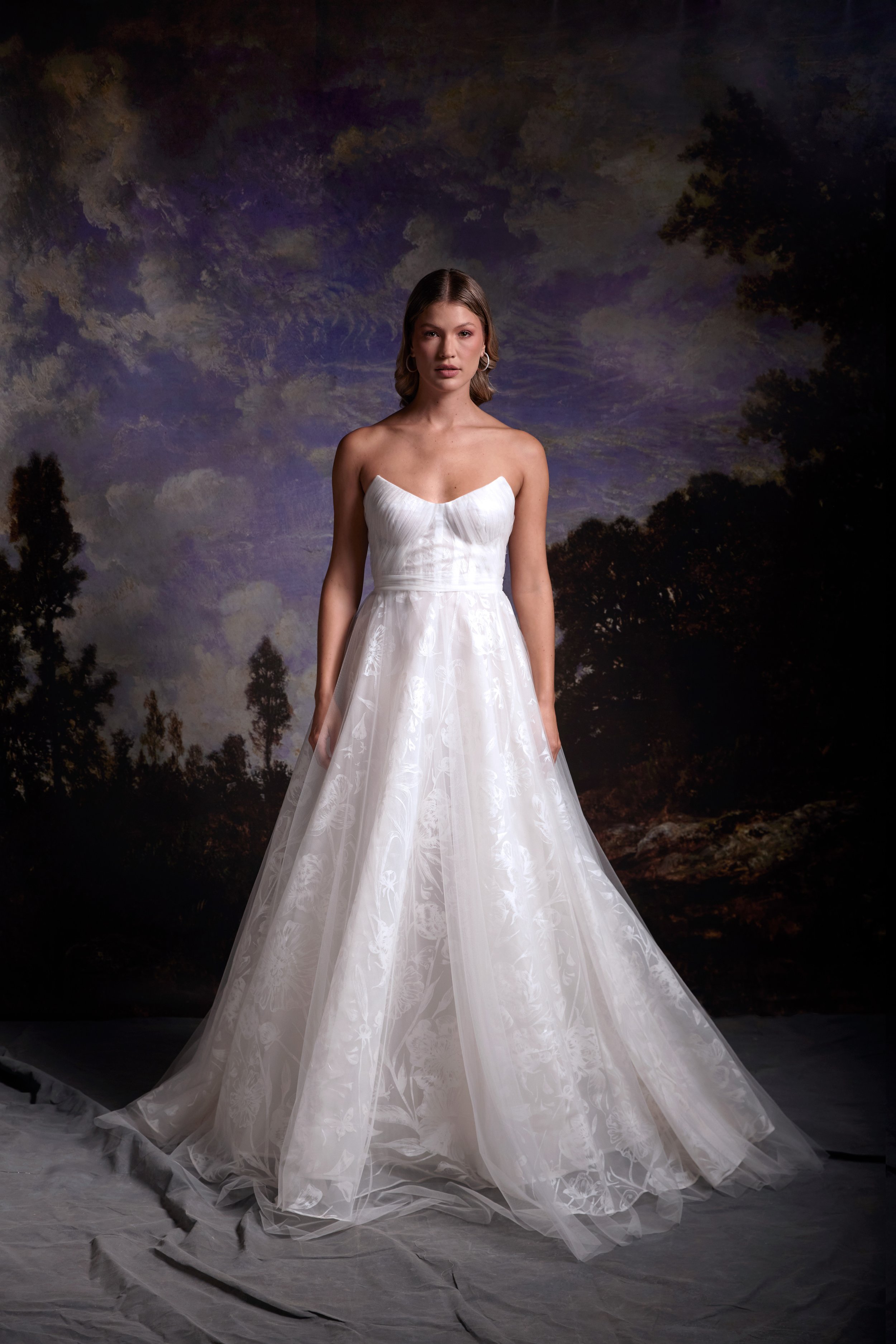 Floral painted strapless gown with underwire bra cups and draped tulle bodice, featuring a circular full skirt and tulle overlay.