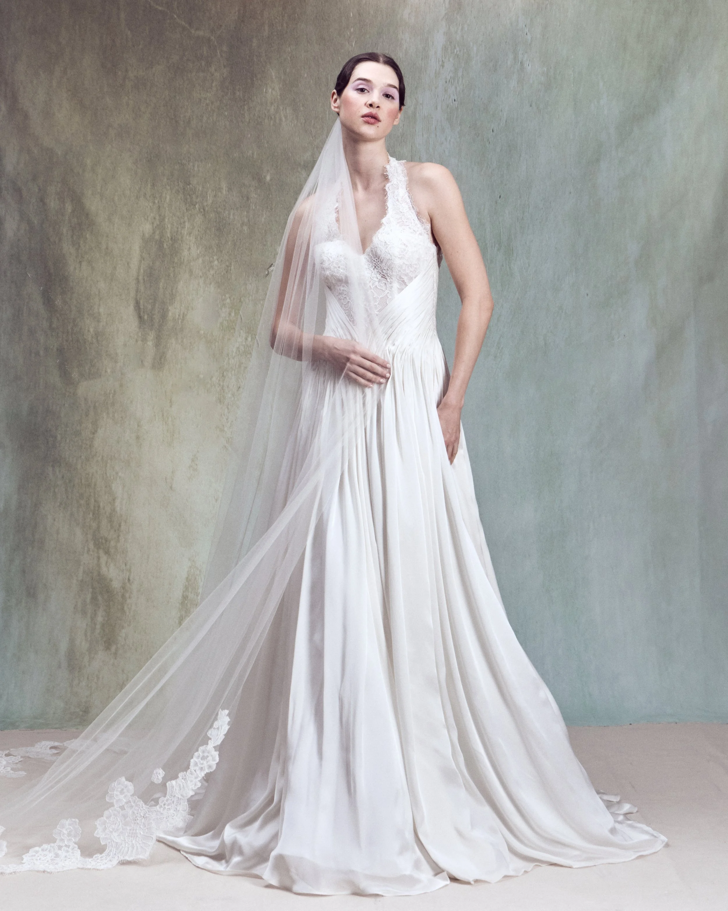 Corded lace applique gown with V-neckline halter bustier and hand-draped silk satin chiffon detail wrapping around the waist. 
