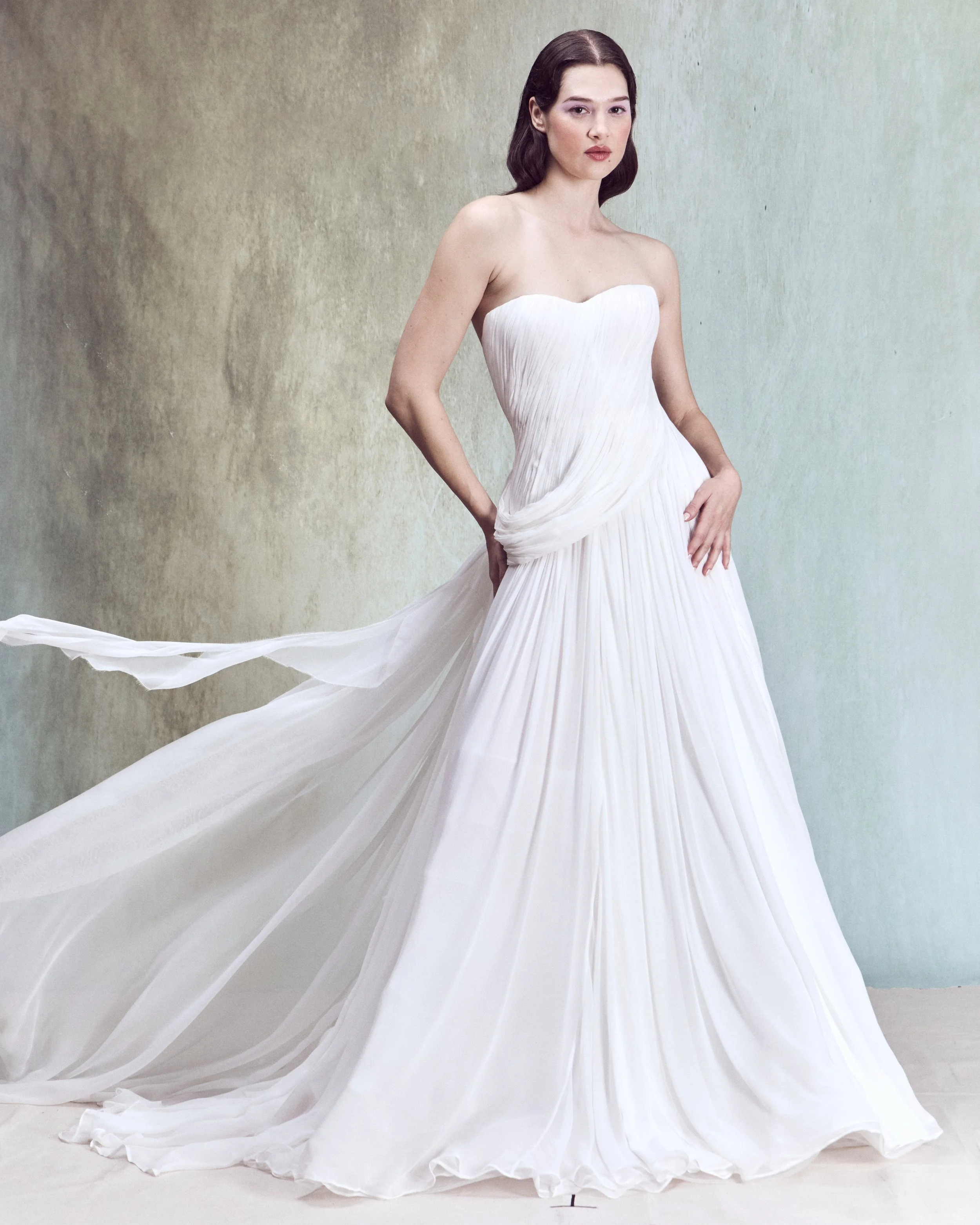 Hand-Draped Silk Chiffon gown with a structured bustier, continuous wraparound draping, and a soft ruffle at the back, with matching chiffon and lace train.