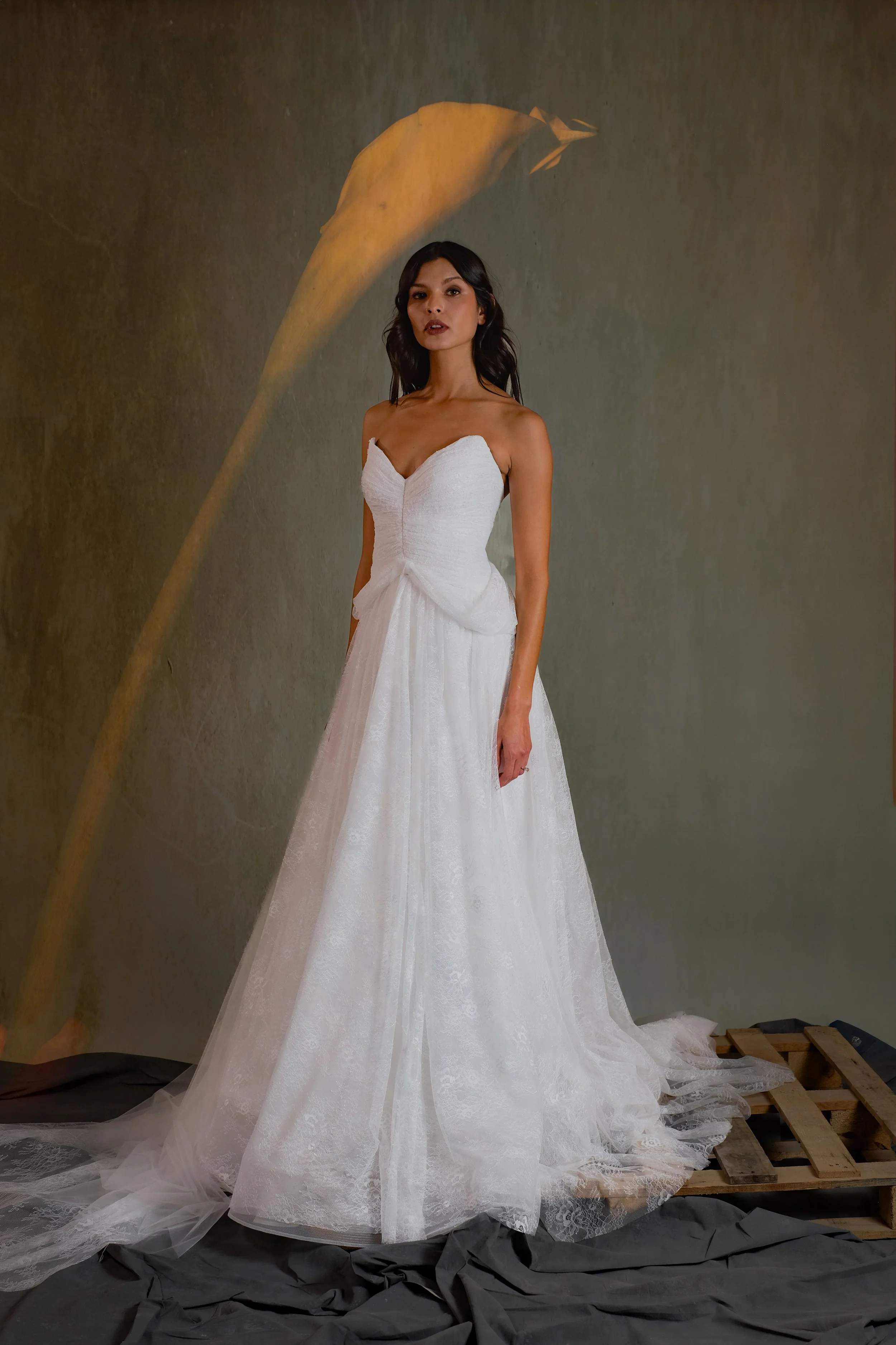 Hand-Draped chantilly lace gown featuring low hip points and soft hip drape.