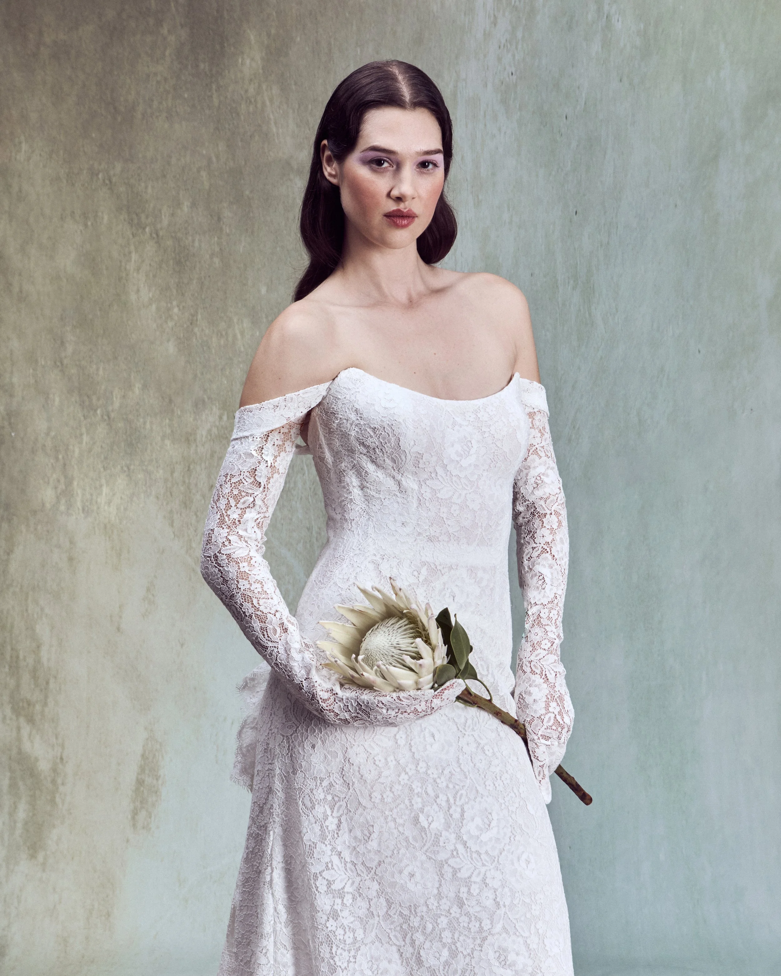 Corded lace A-line with strapless drop-waist bustier and removable straps paired with matching gloves. 