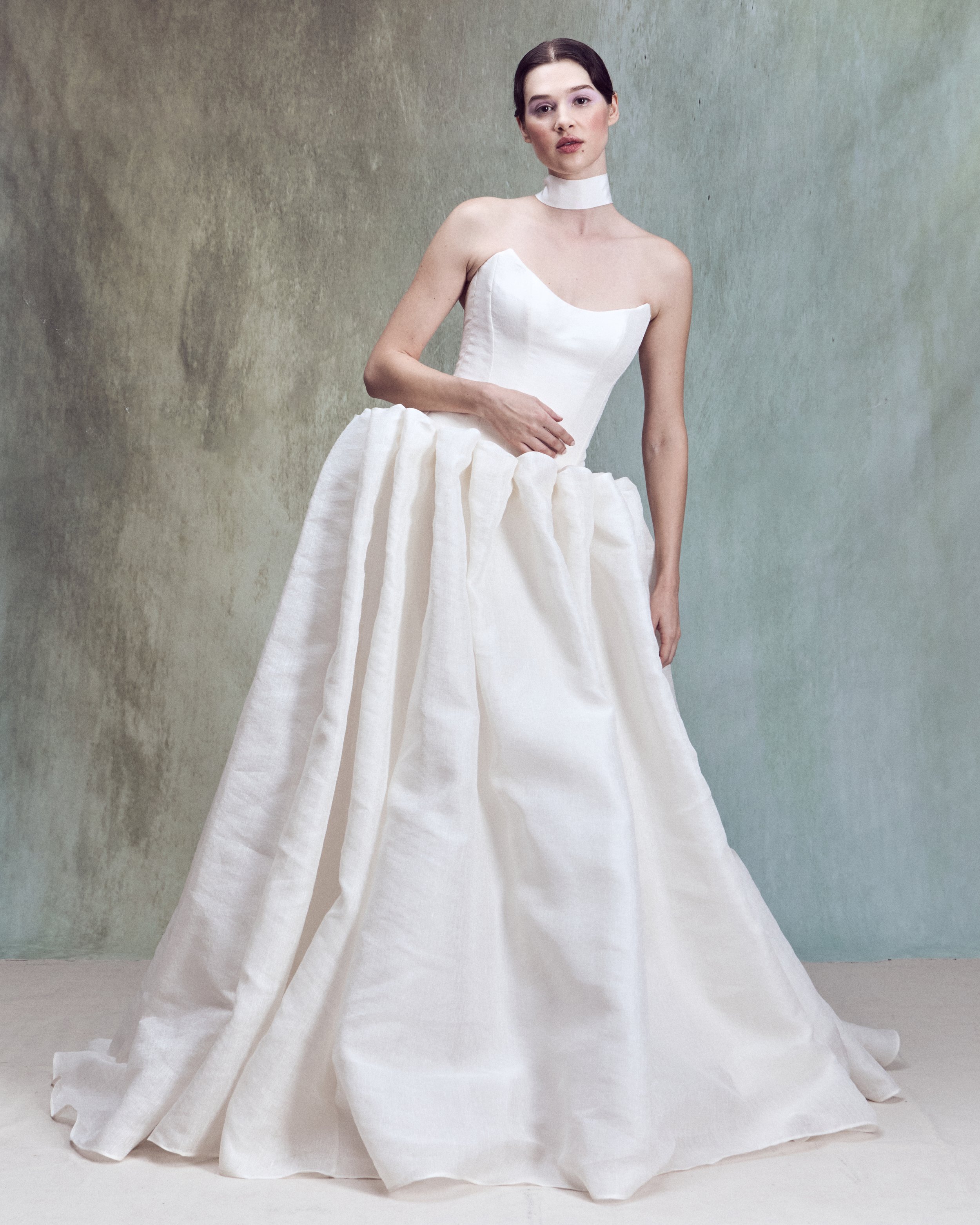Strapless Silk Linen ball gown with a pointed neckline and a a drop-waist skirt, individually hand-draped into sculptural folds to create exaggerated volume