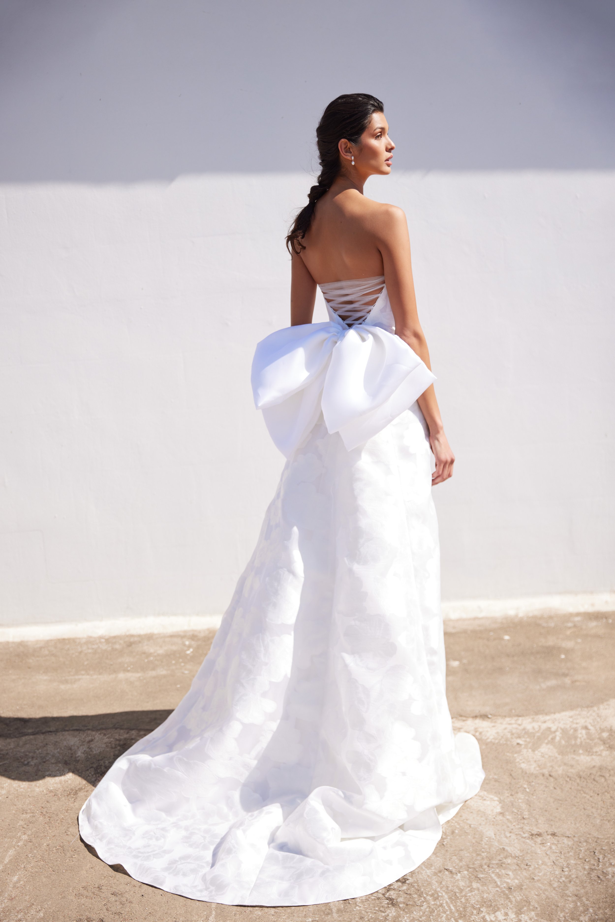 Floral jacquard strapless gown with “A” line skirt, laced back bustier and charra silk removable bow.