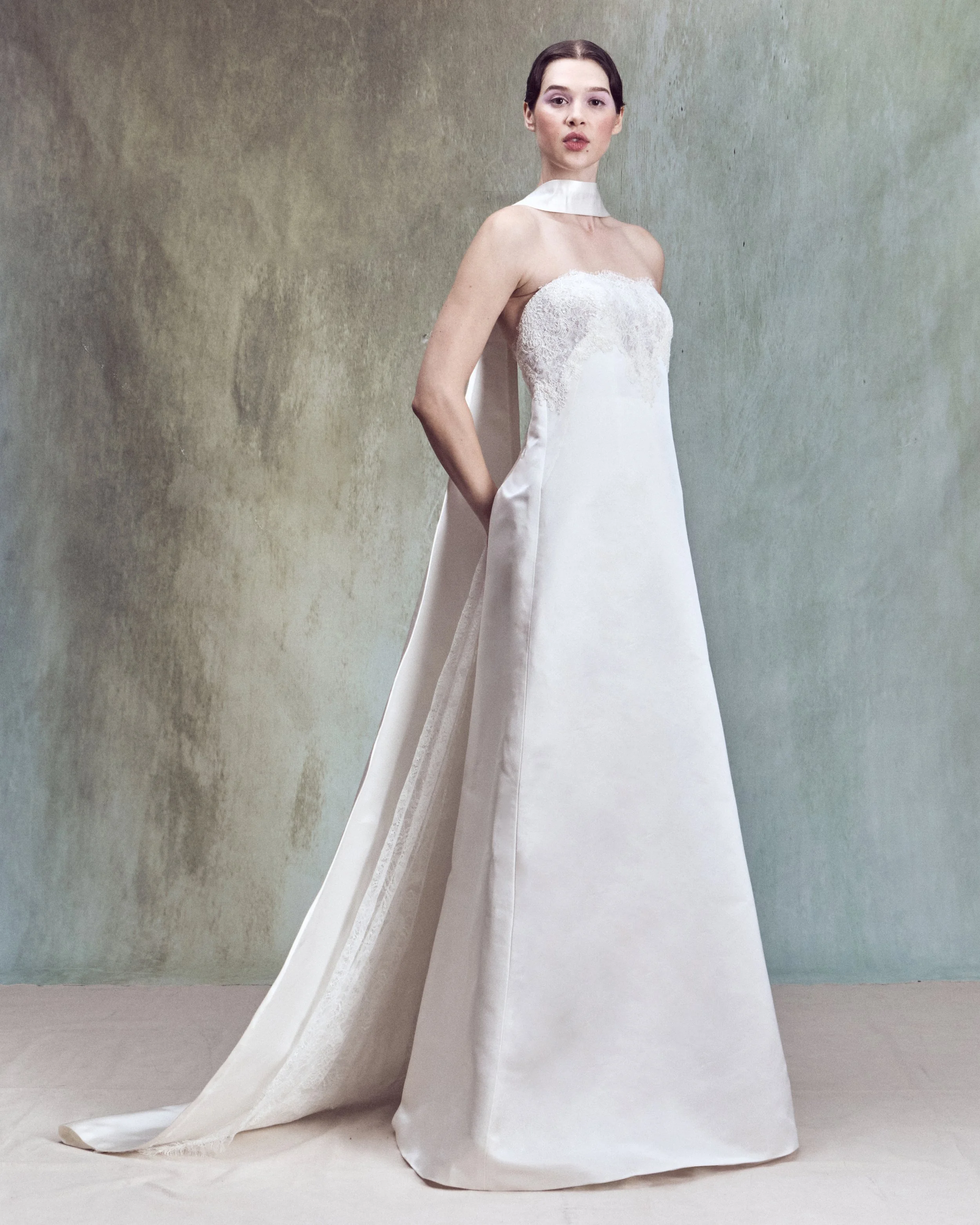 Strapless corded lace applique column gown with a low back, an integrated matching bustier, and removable folding train with chantilly lace detail inside.