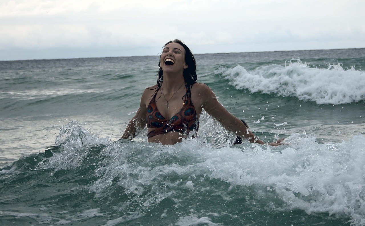 Person leaping out of the ocean's waves in joy