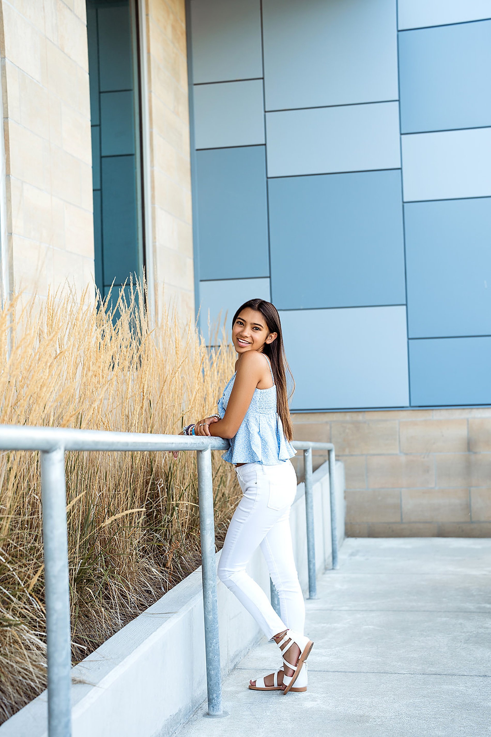  senior girl leans against railing in Kansas City 