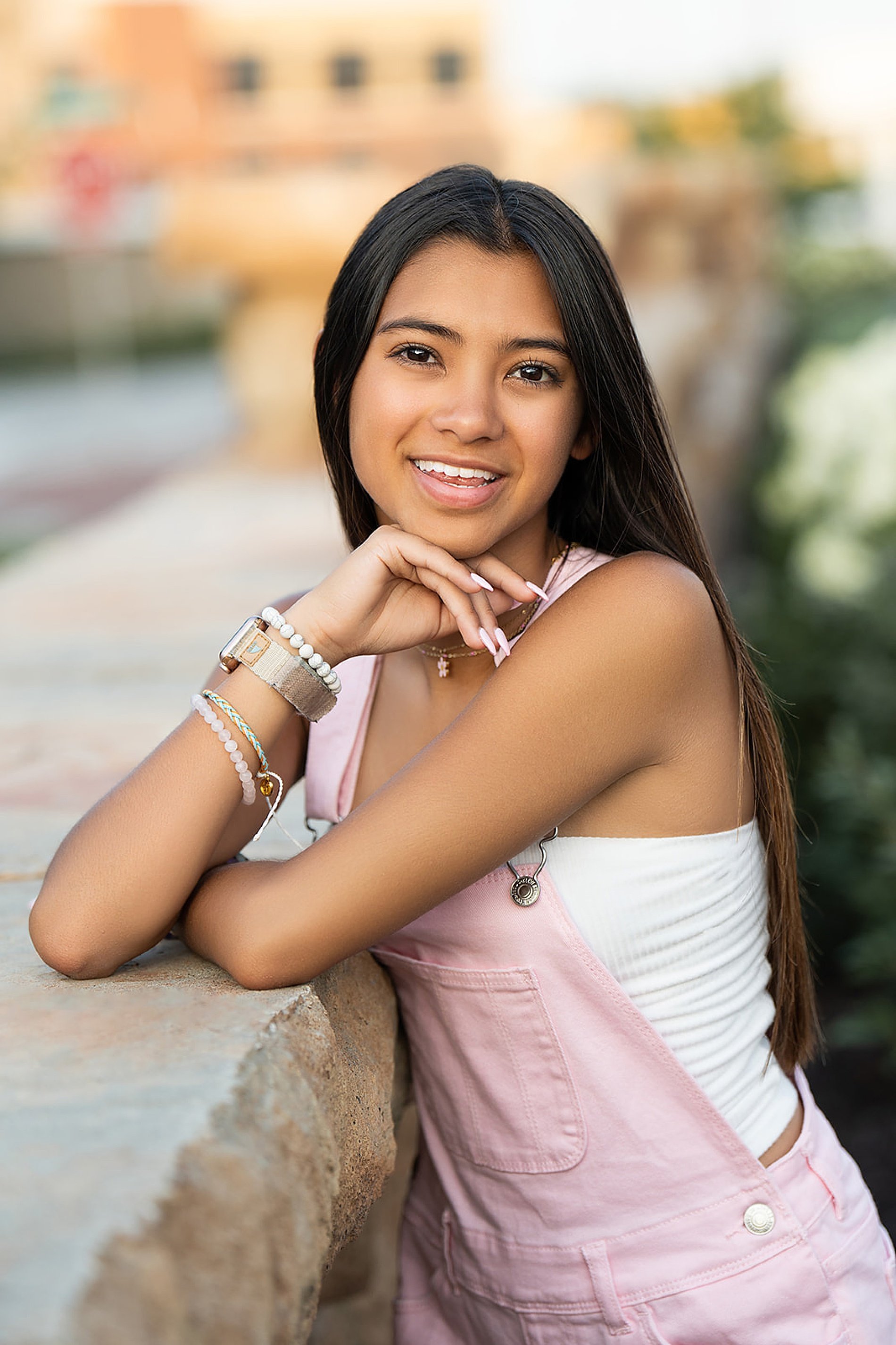  Senior girl leans up against stone ledge 