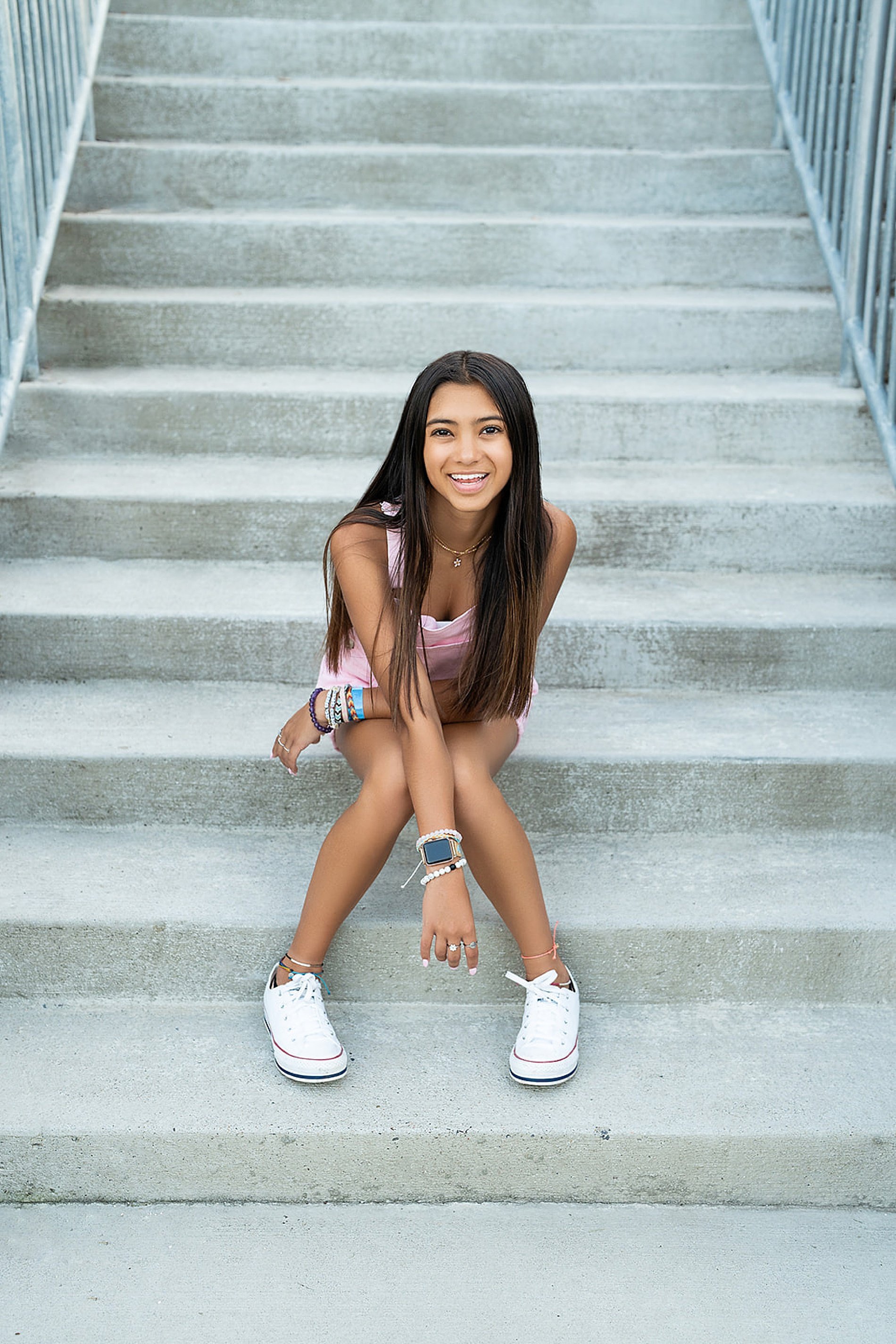  Senior girl sits on concrete steps in KC  