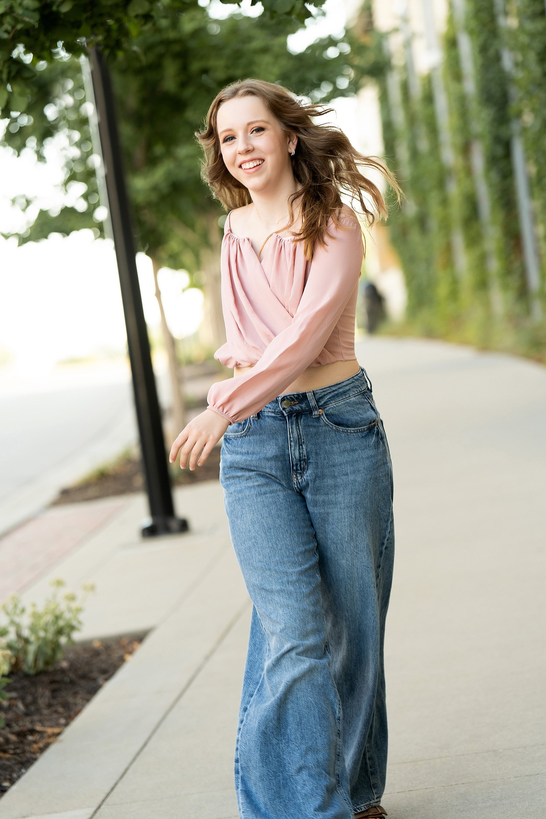  Senior girl walks down sidewalk in Kansas City 