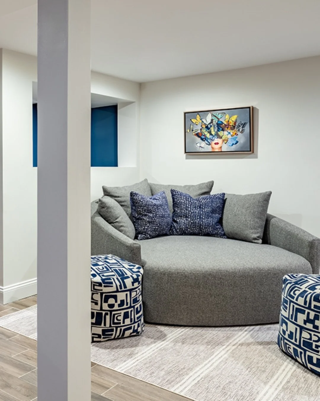 In this basement lounge area, an oversized round chaise with punchy ottomans is perfect for the kids when they want to hang out. 

For the arts and crafts area, we were able to upcycle the old kitchen table and chairs to make messy fun completely str