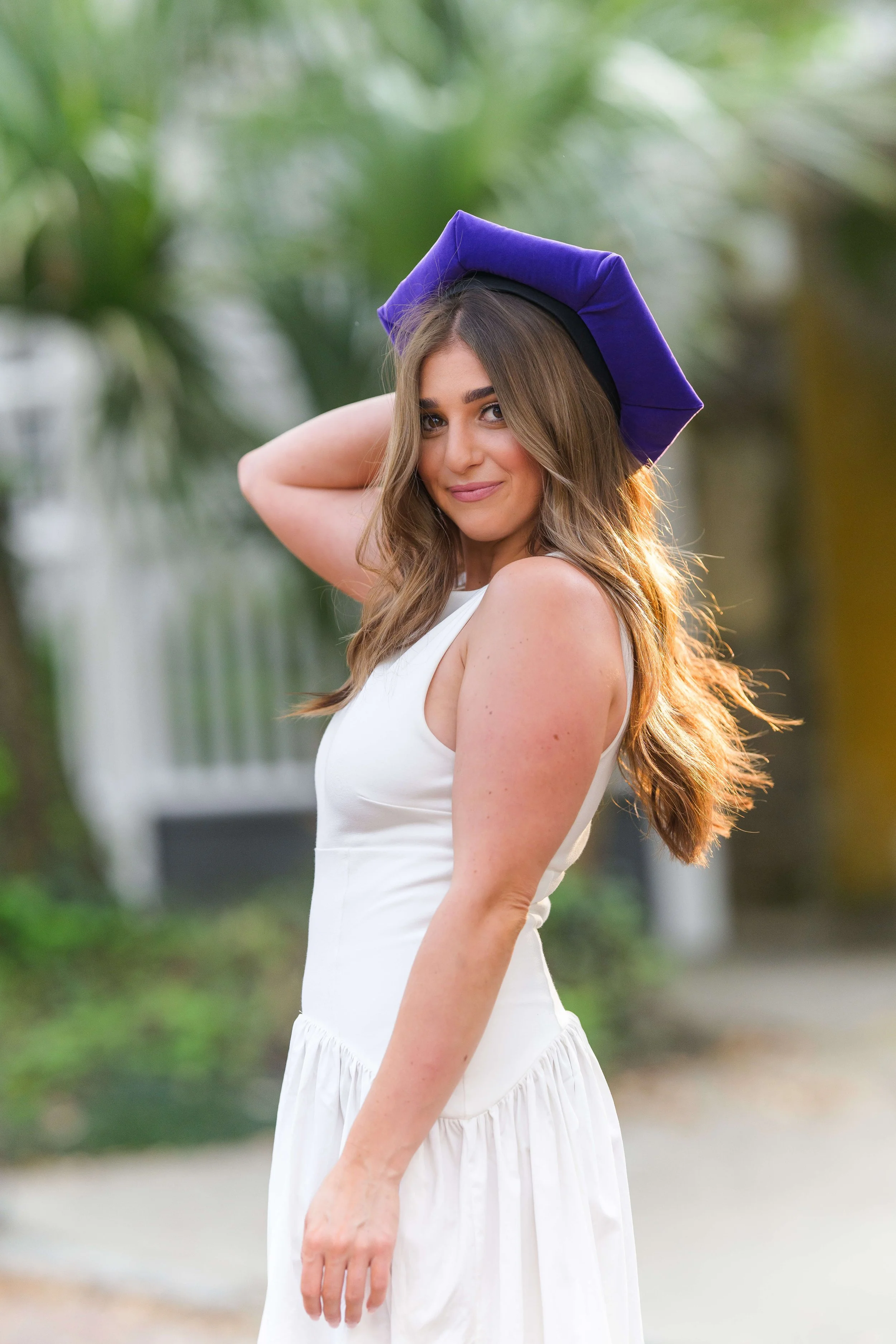 Charleston School of Law Grad Student in purple cap smiling at the camera