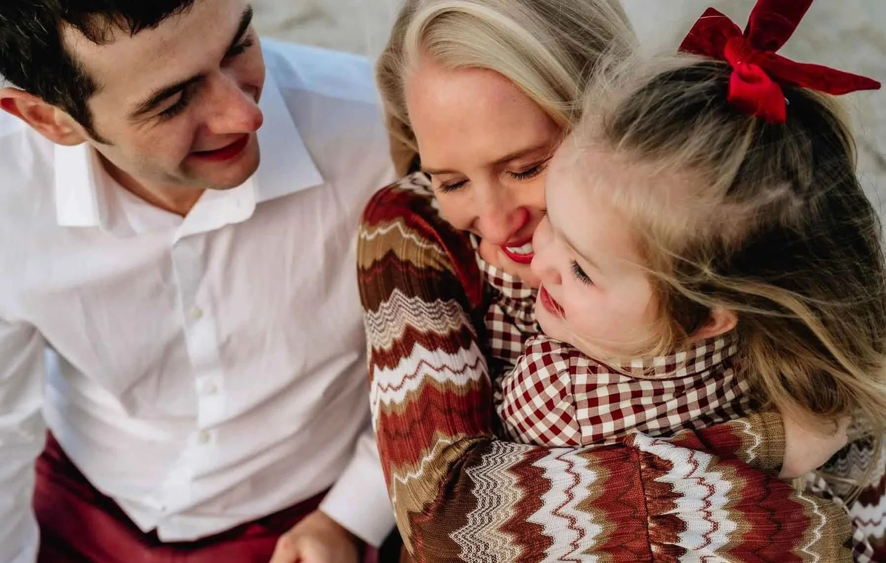family-hugging-at-beach-young-child.jpg