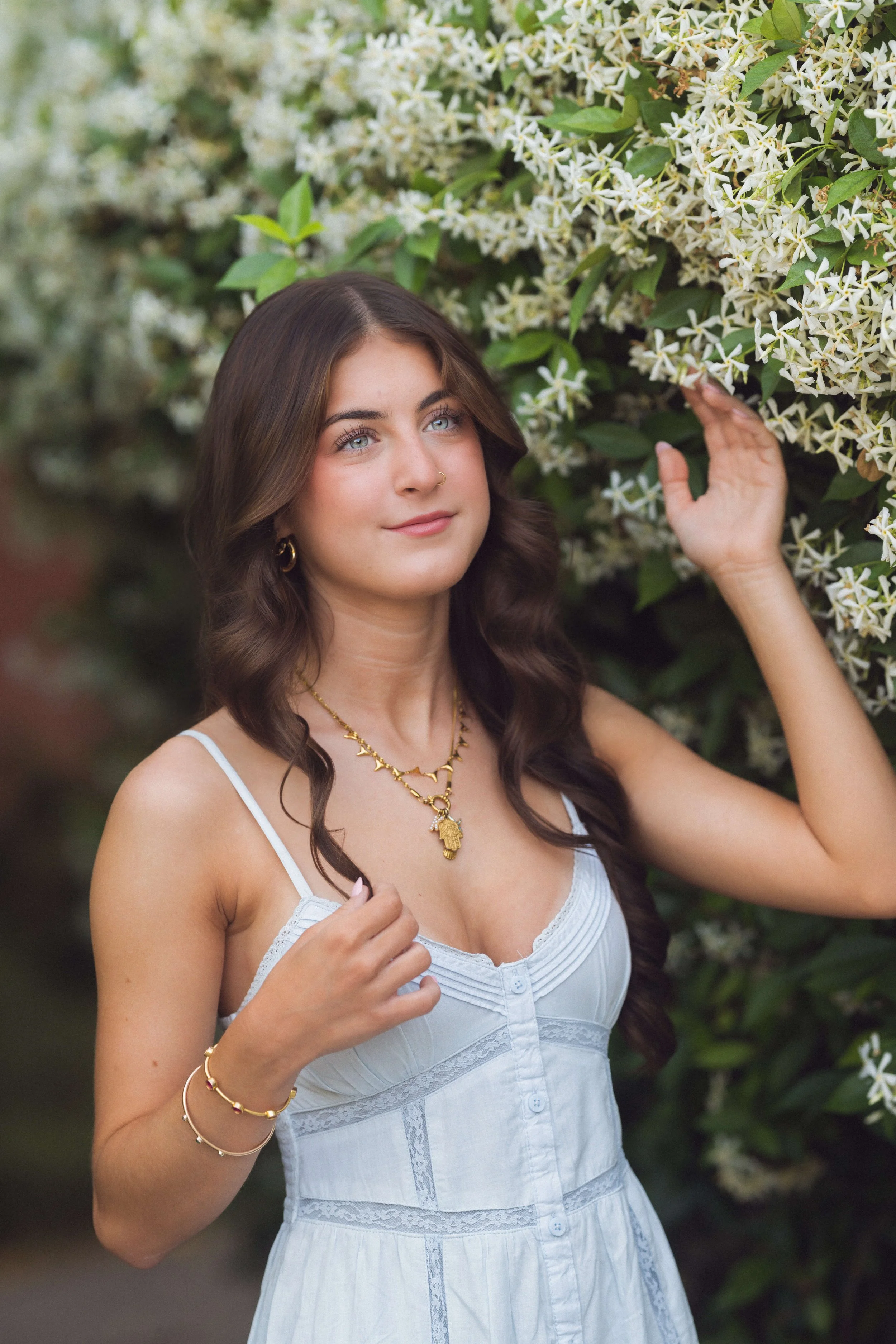 Charleston senior portrait with white jasmine blooms, gold jewelry detail, pale blue dress