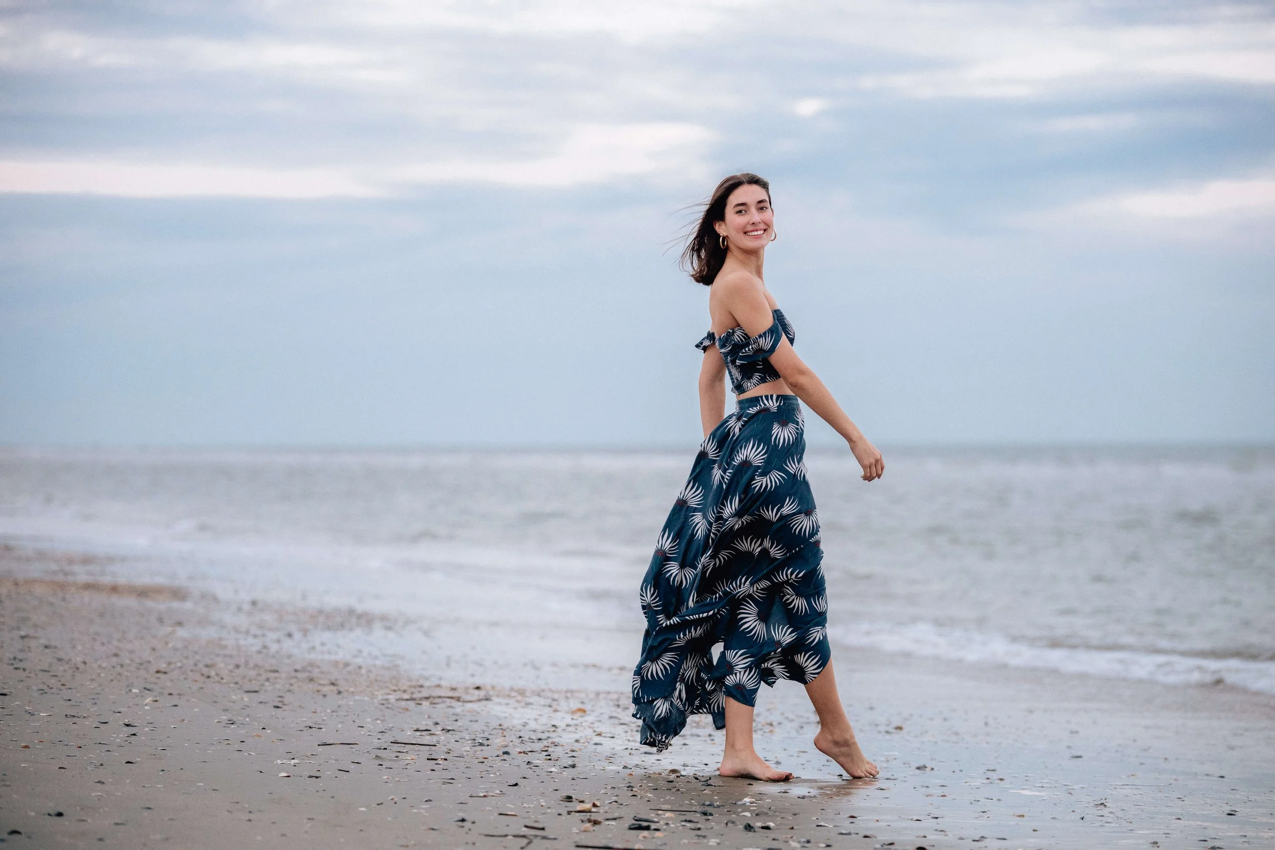 girl walking on shore at IOP at sunset.

