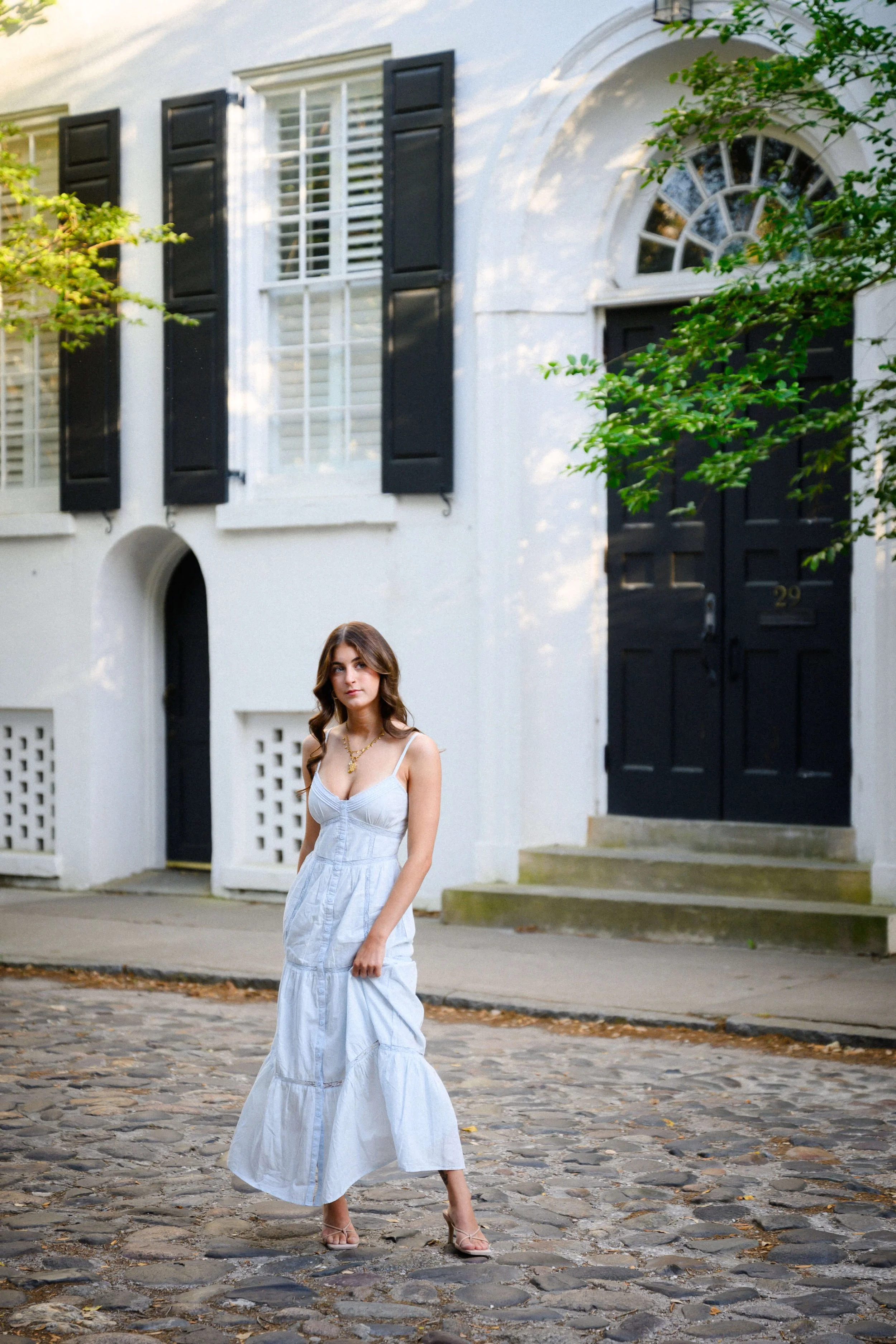 Charleston senior portrait French Quarter cobblestone street historic home black shutters