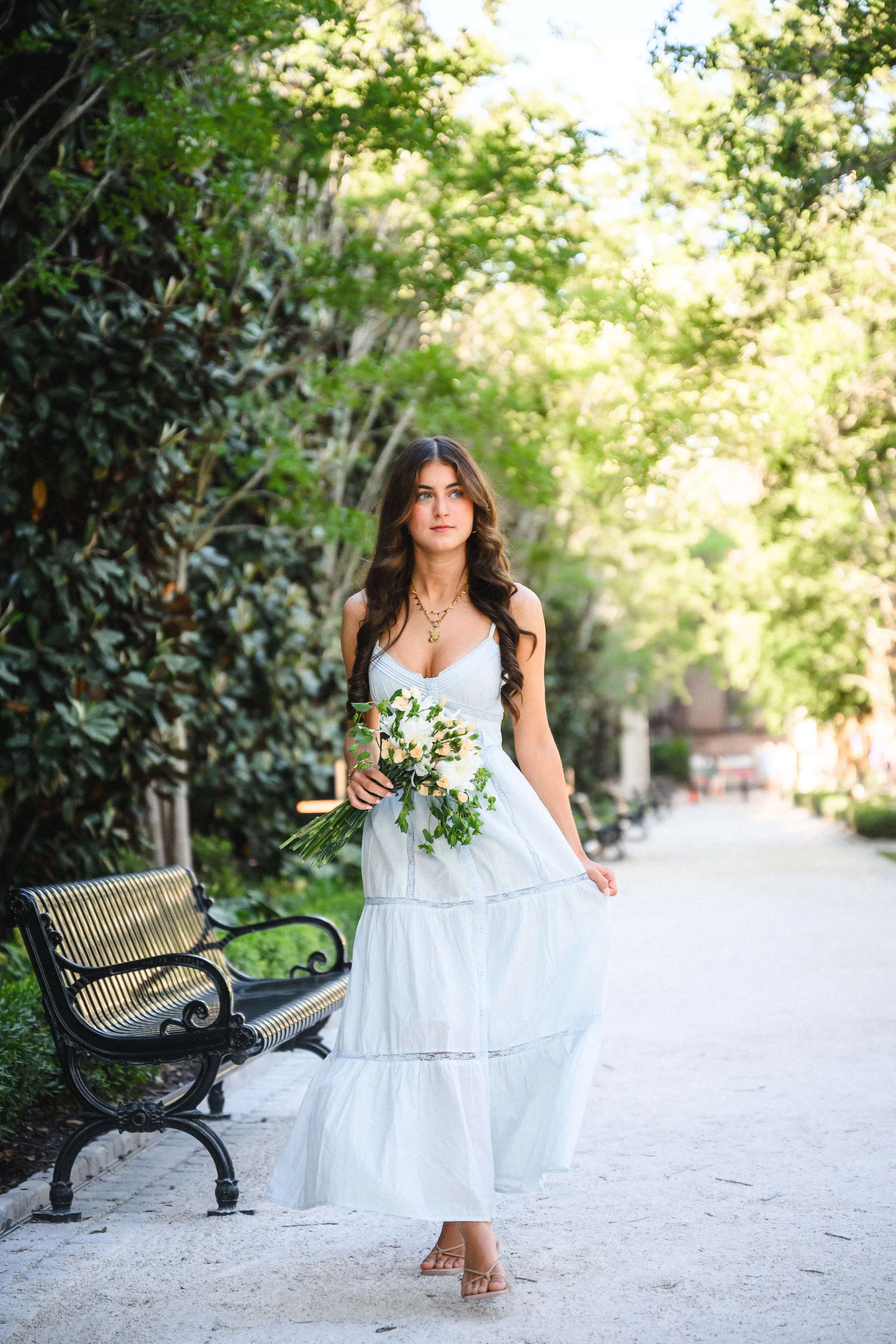 Charleston senior portrait light filled garden path and magnolia trees