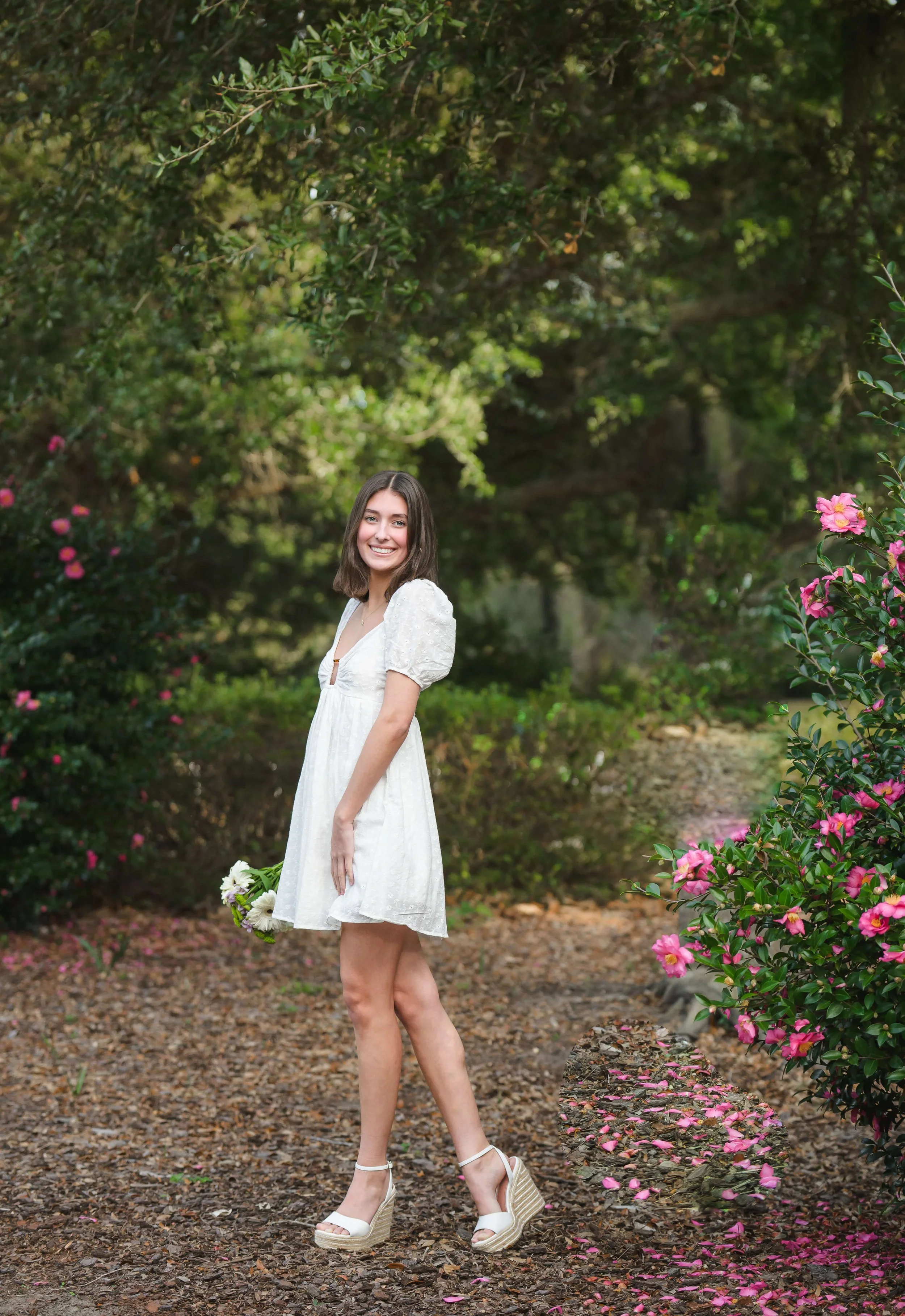 Girls posing with Camellia flowers at Hampton Park in Charleston for senior photos