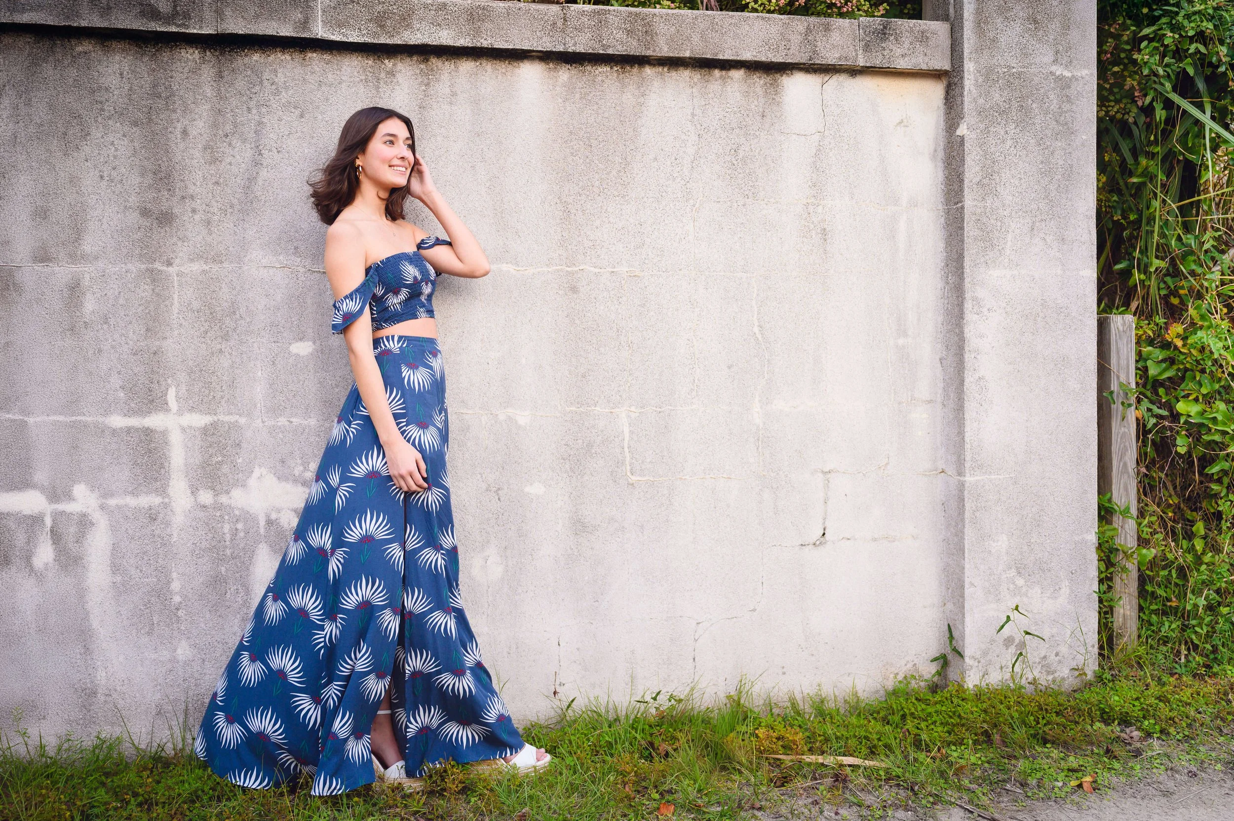girl posing against cement wall at IOP beach path in SC for senior portraits
