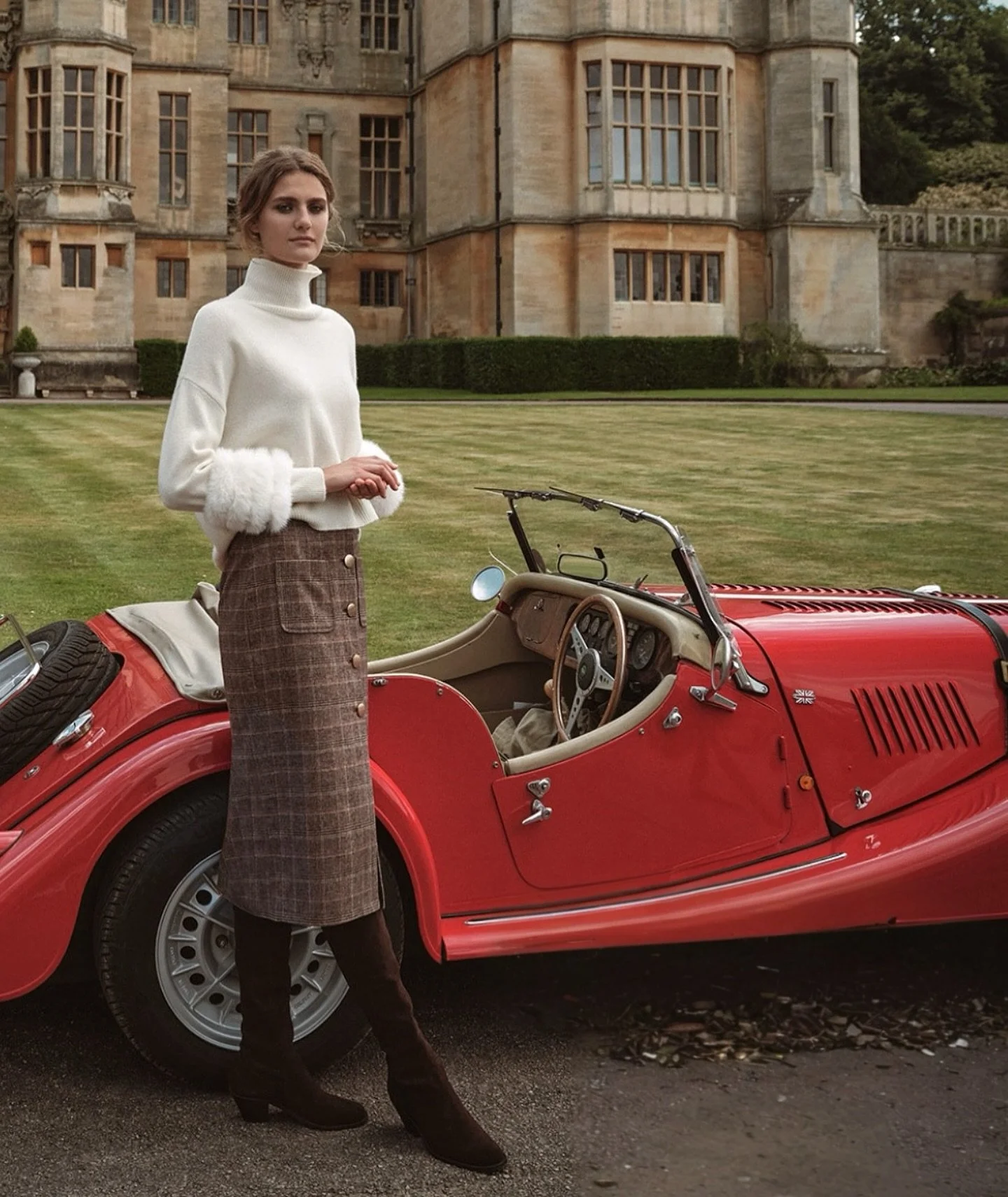 Heritage tailoring meets quiet luxury.
The Belmont Sweater, with its refined ivory knit and detachable fur cuffs, is paired with the impeccably cut Lyndon Skirt in check wool. An ensemble designed for timeless elegance — sophisticated, feminine