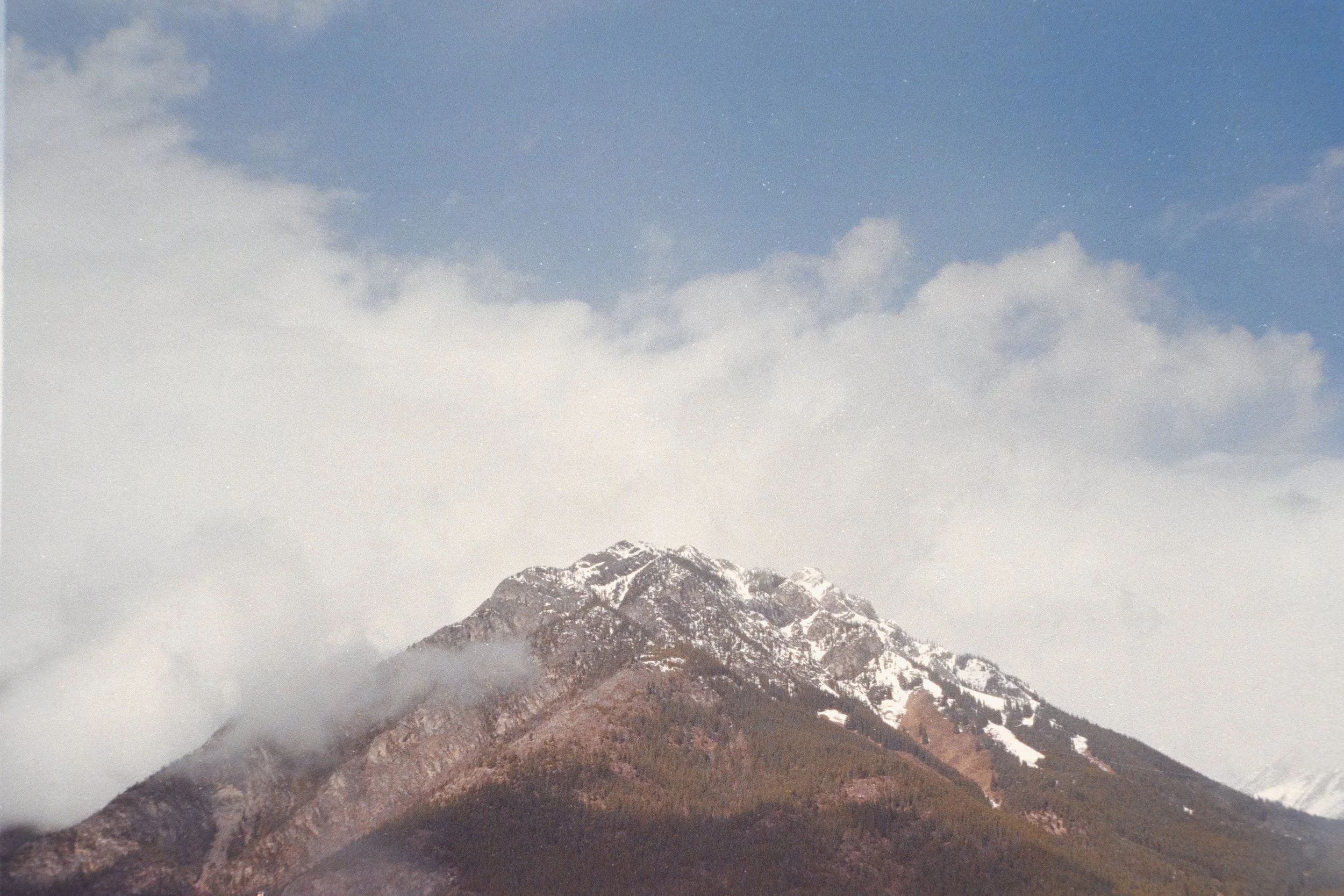 Snow-capped mountain peaks with a partly cloudy sky.