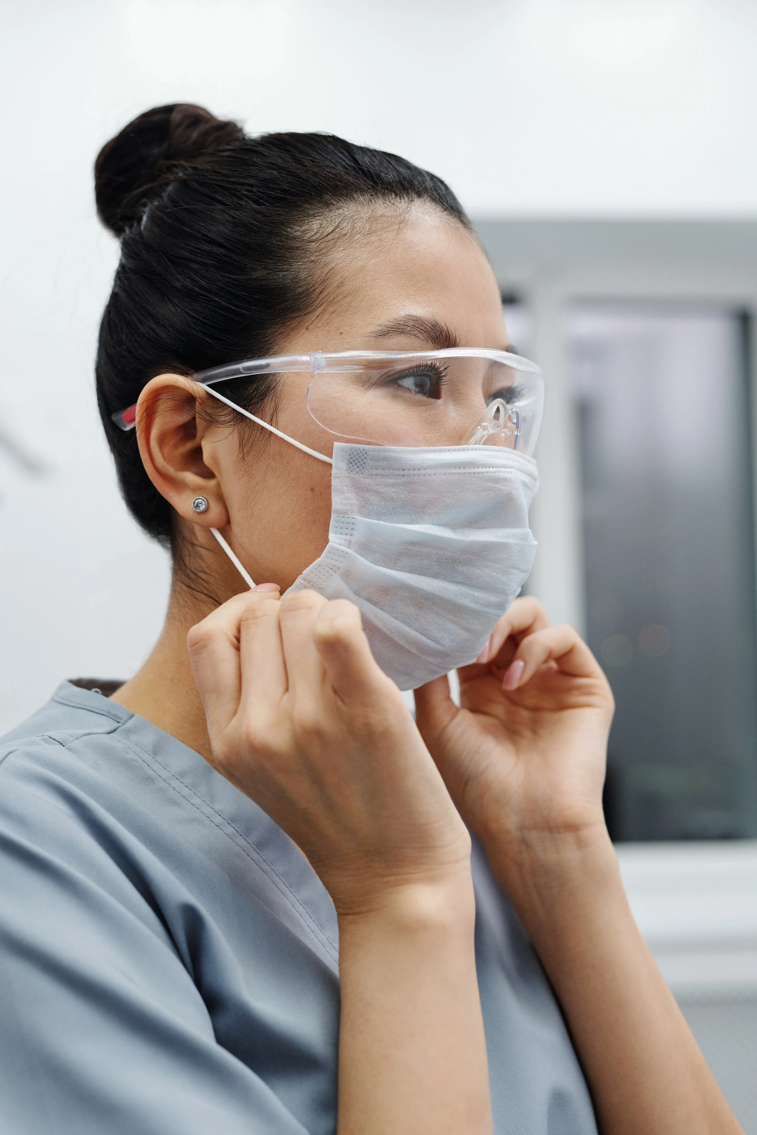 Woman in medical mask and clear, protective glasses