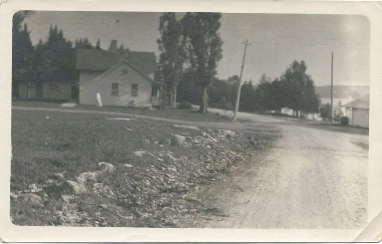 Print: B&W photograph in sepia tones of Anderson Home, facing north side of house, looking south down dirt road.
(2012.123)