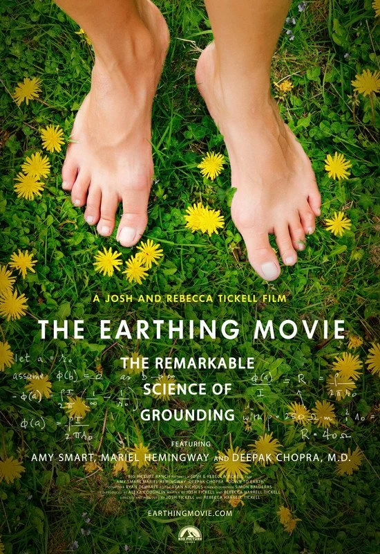 Close-up of bare feet on grassy ground with yellow flowers, promoting the film 'The Earthing Movie' about grounding science, featuring Amy Smart and Deepak Chopra.