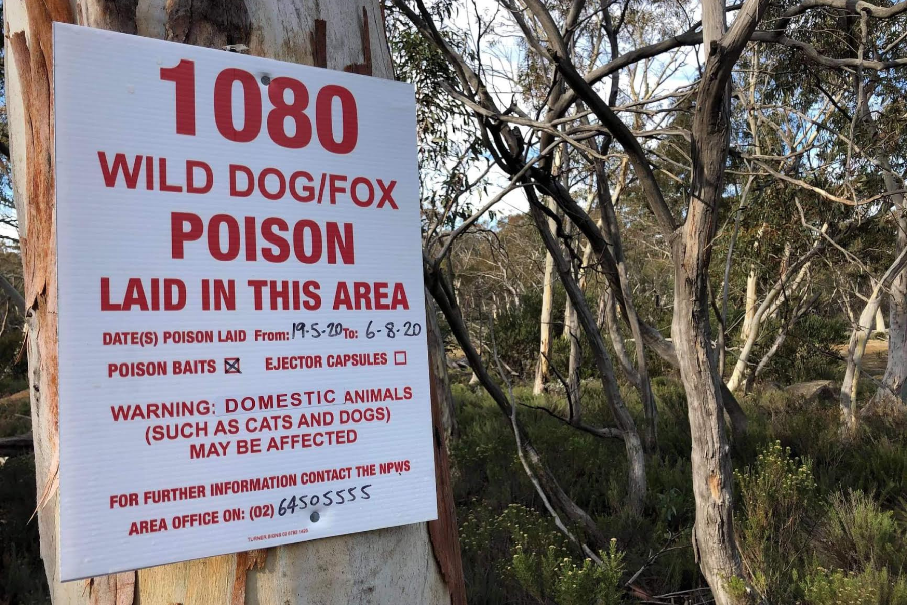 1080 poison warning sign installed in an Australian public landscape
