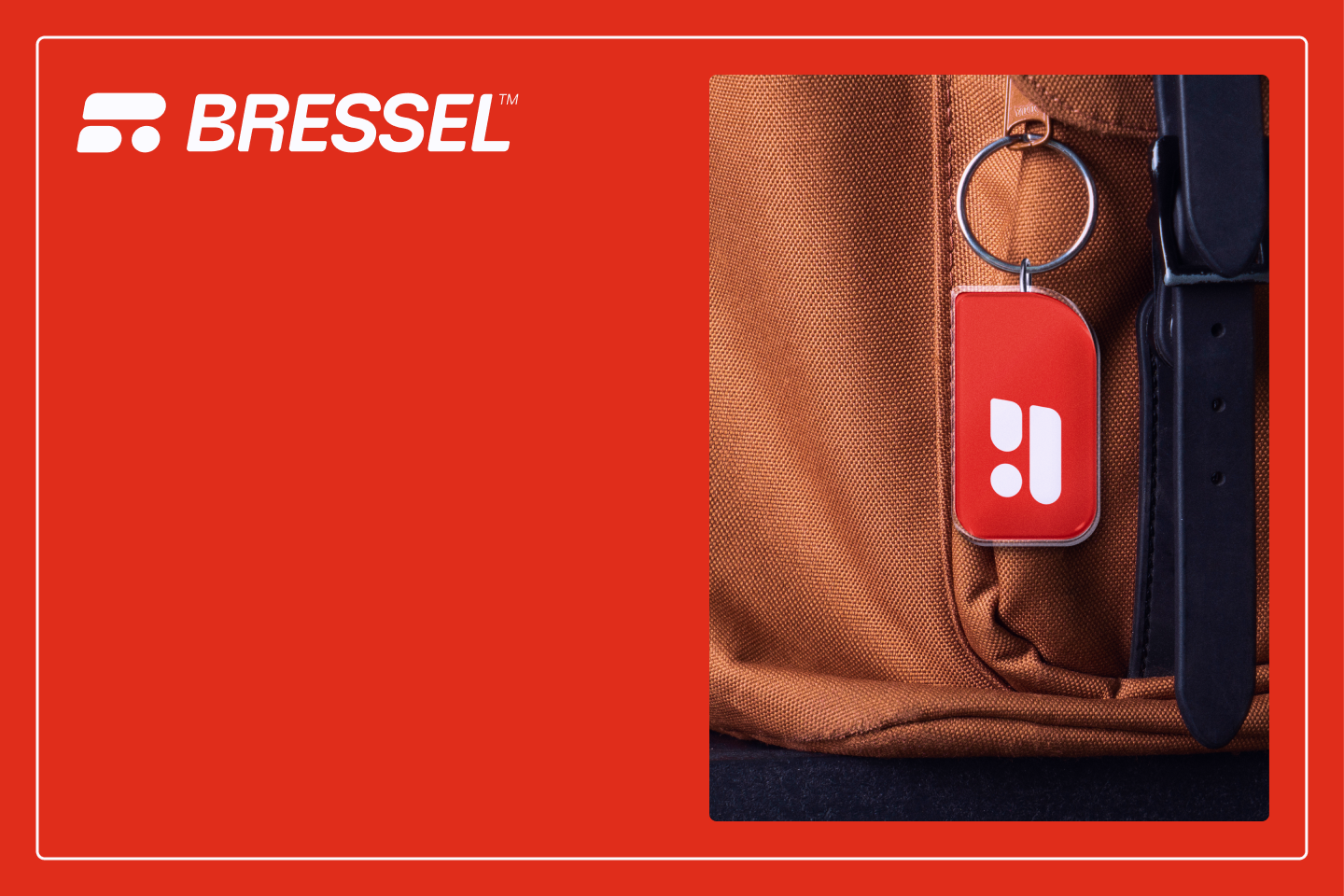 Close-up of a brown backpack with a red keychain attached, showing a white logo, and a black strap.