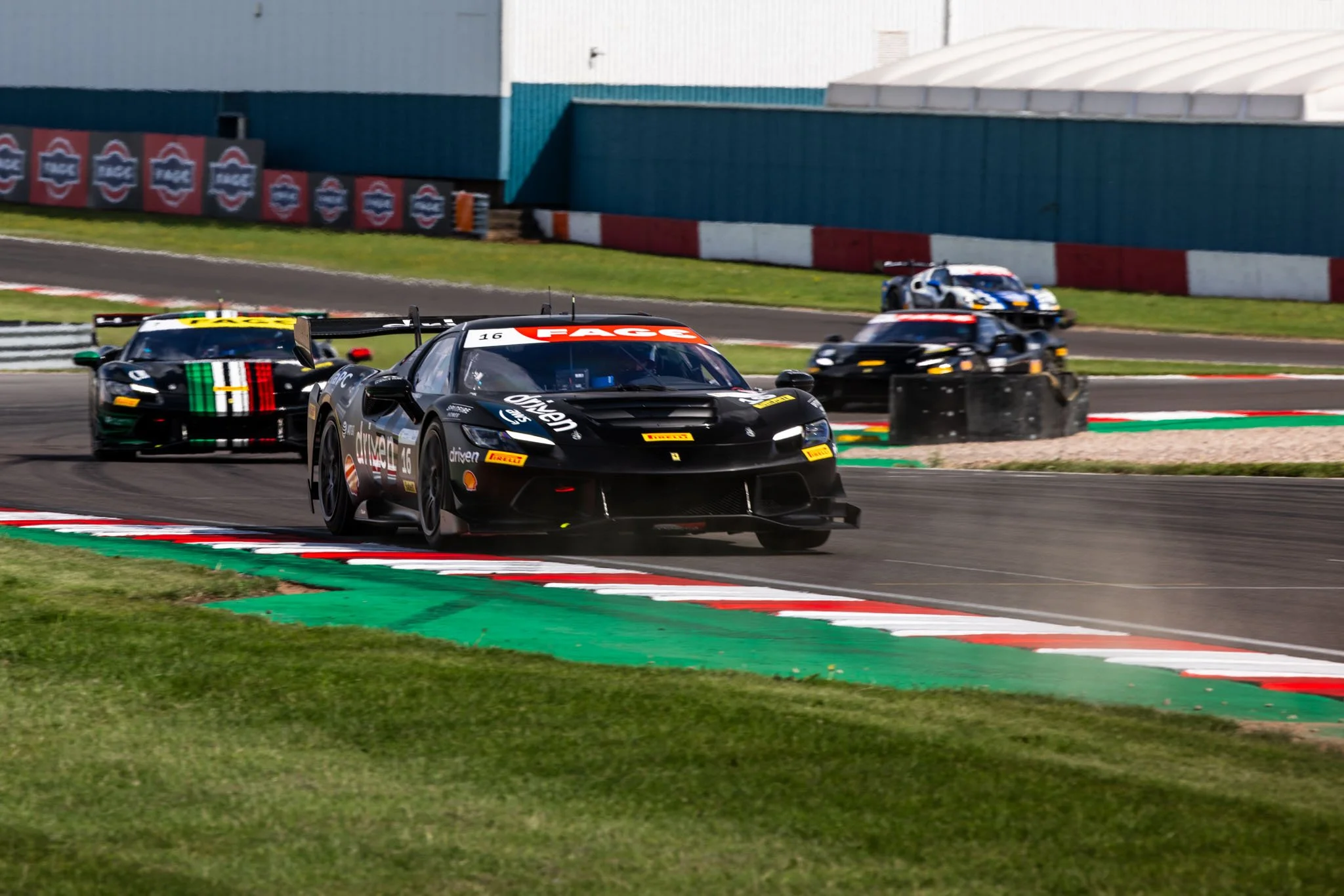 Multiple race cars navigating a turn on a race track during a motorsport event.
