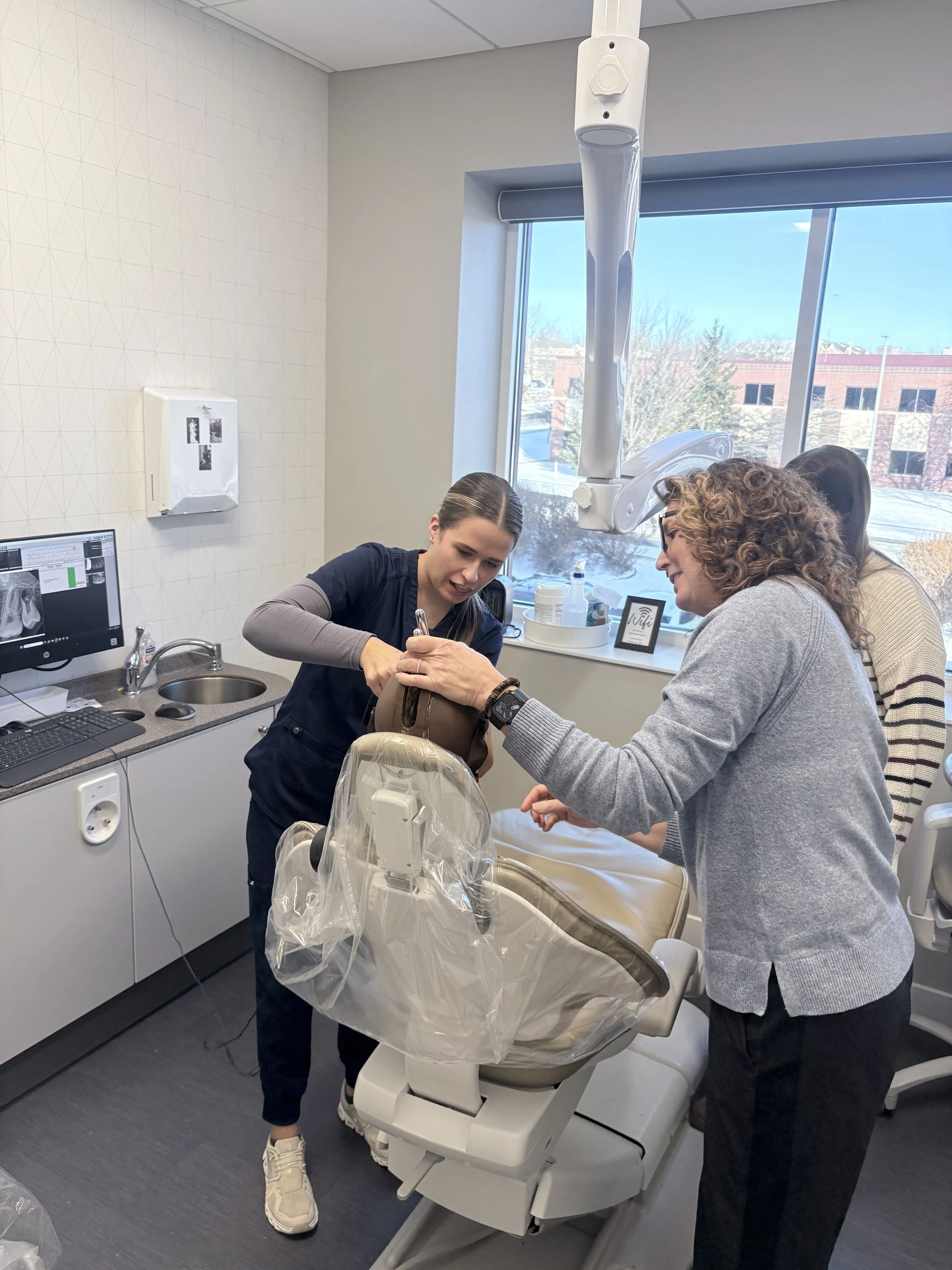Reagan demonstrating ideal sensor placement with the team at Capitol Endodontics.